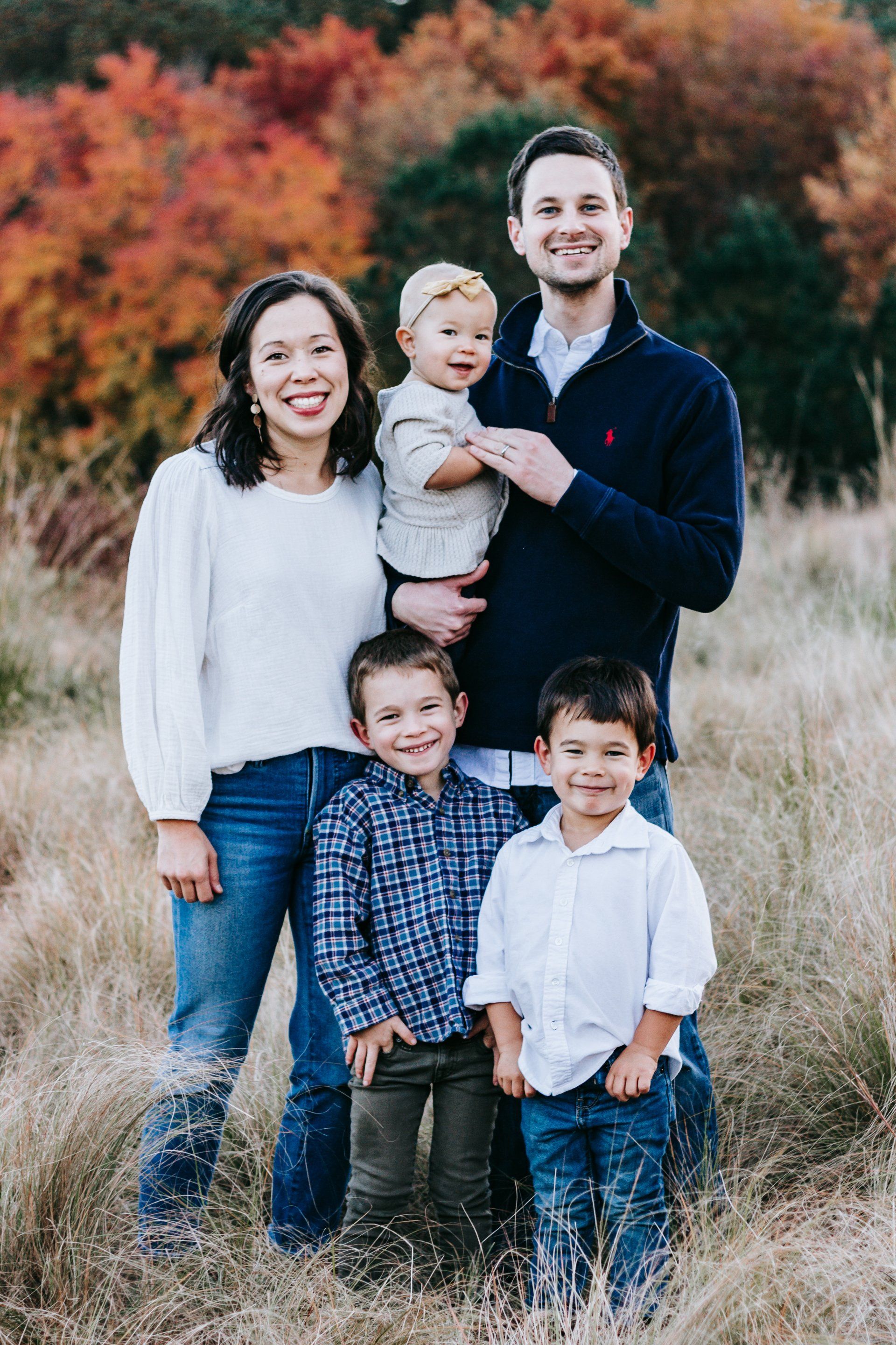A family is posing for a picture in a field.