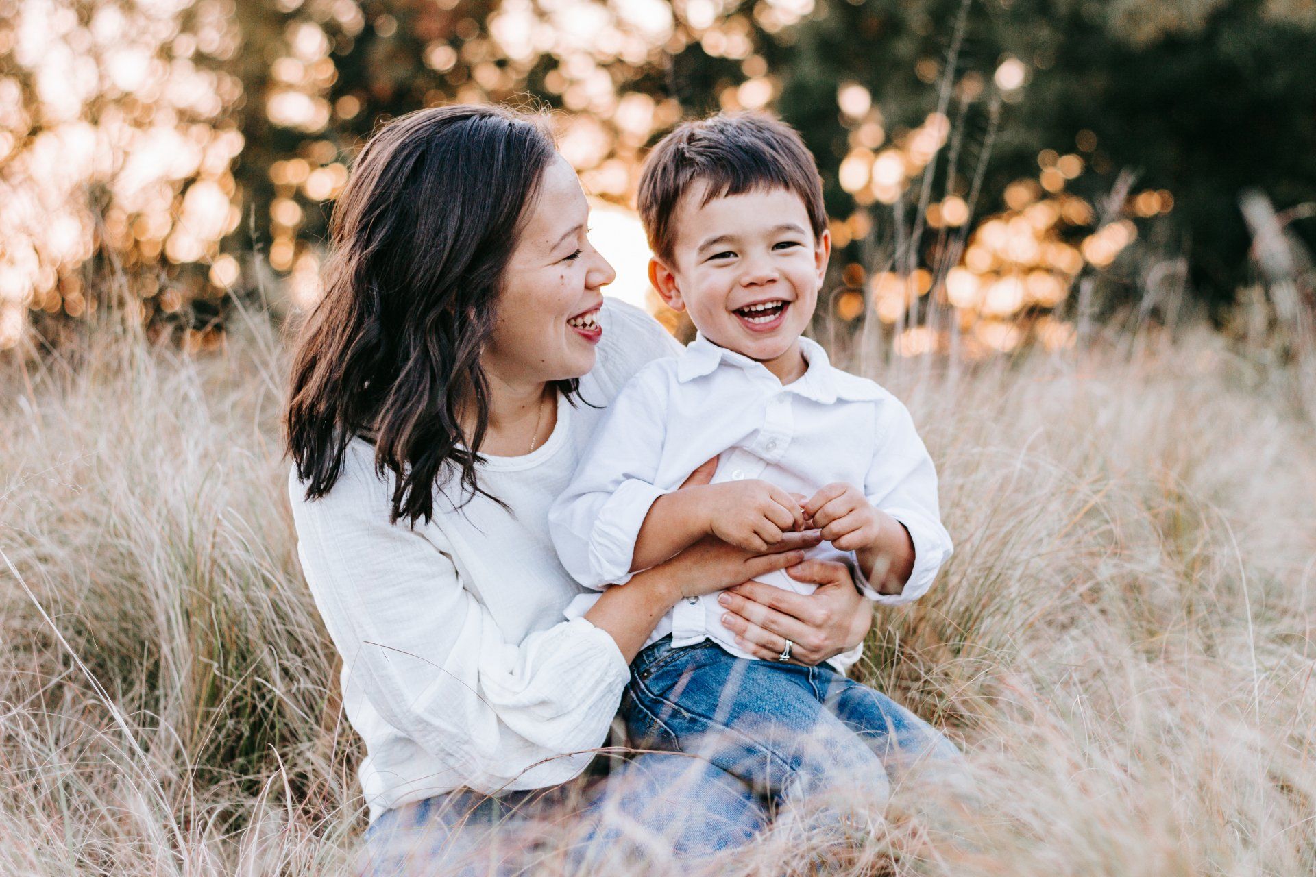 A woman is holding a child in her arms in a field.