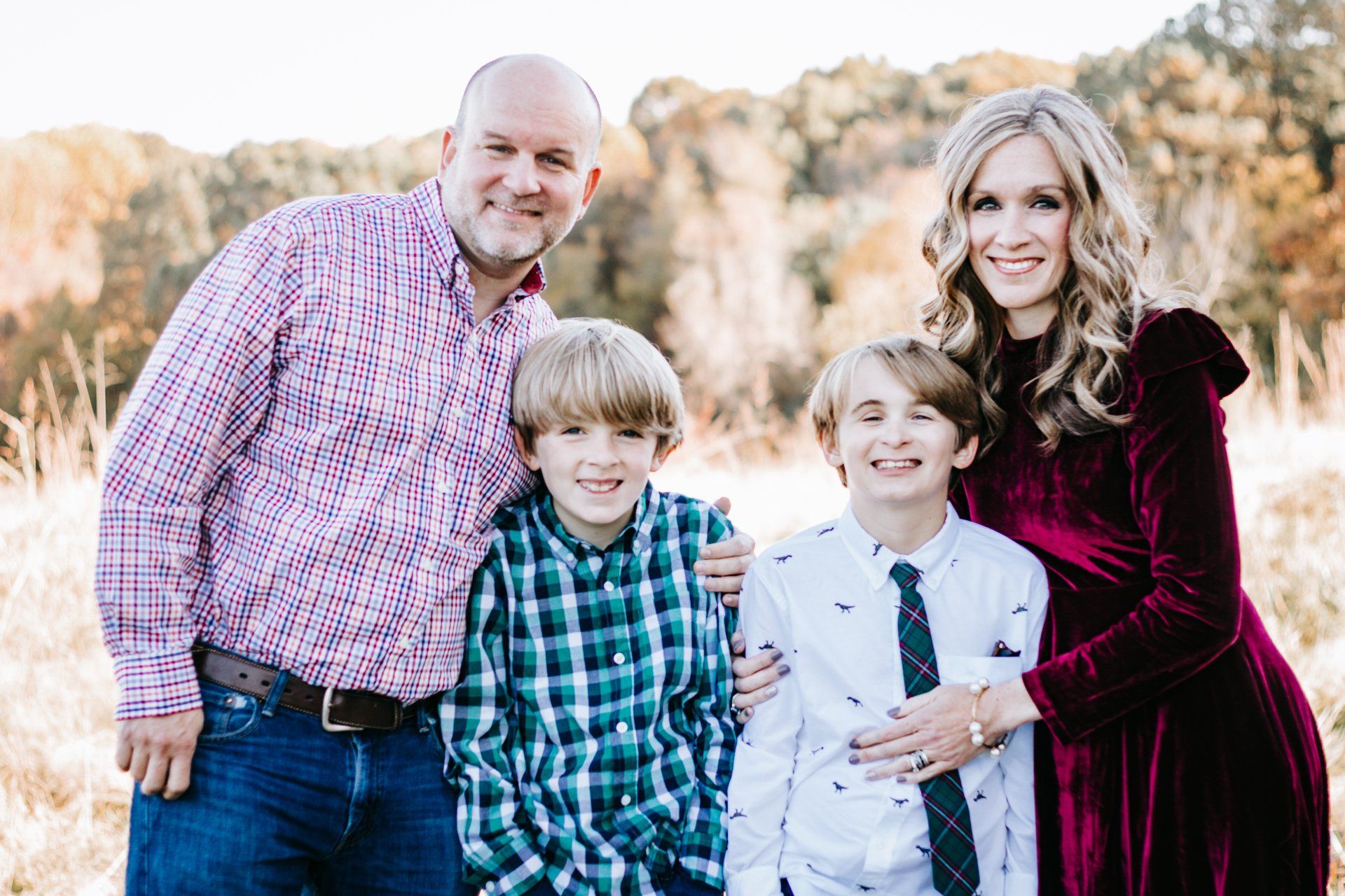 A family is posing for a picture together in a field.