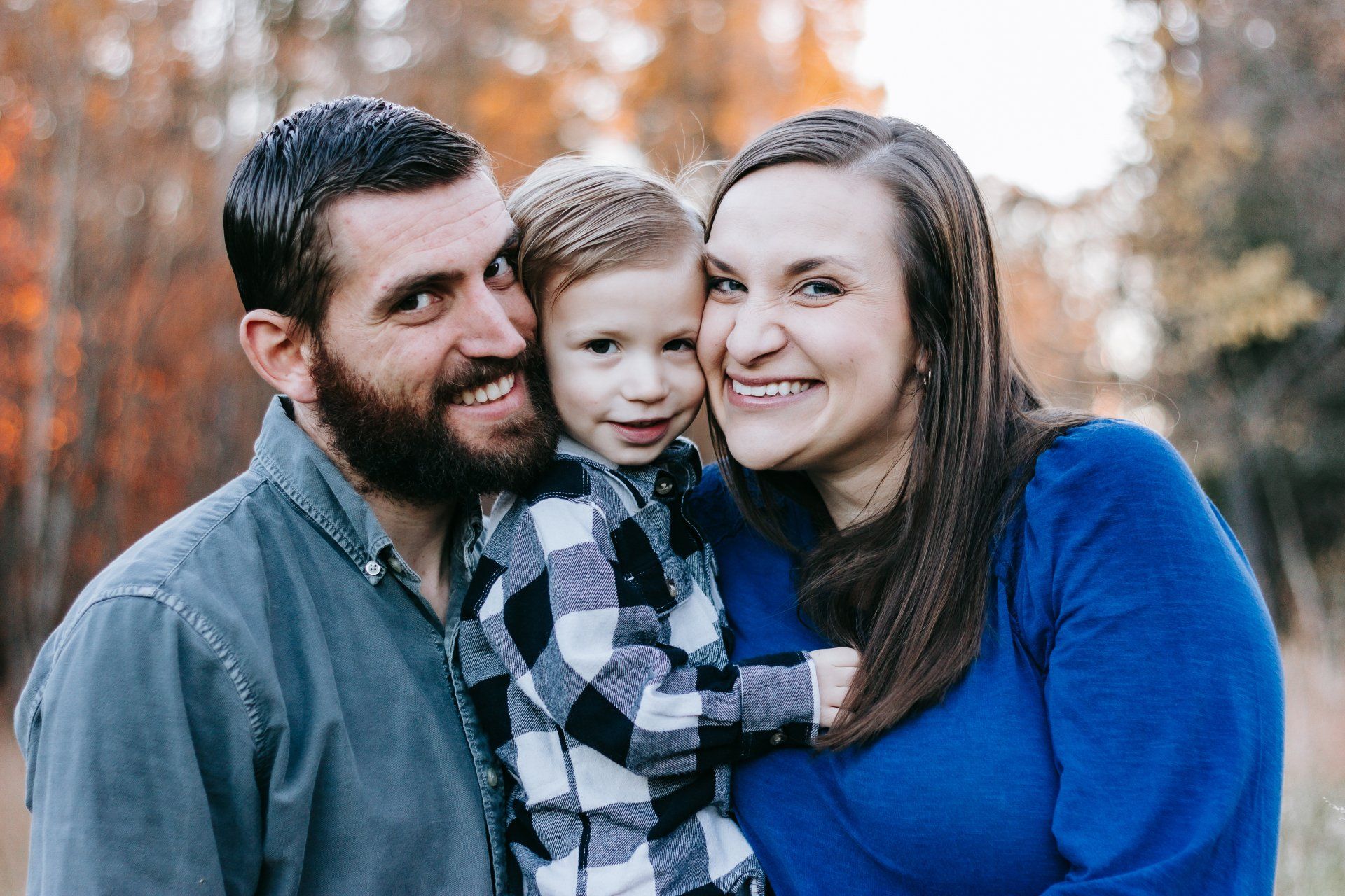 A man and woman are holding a little girl and smiling for the camera.