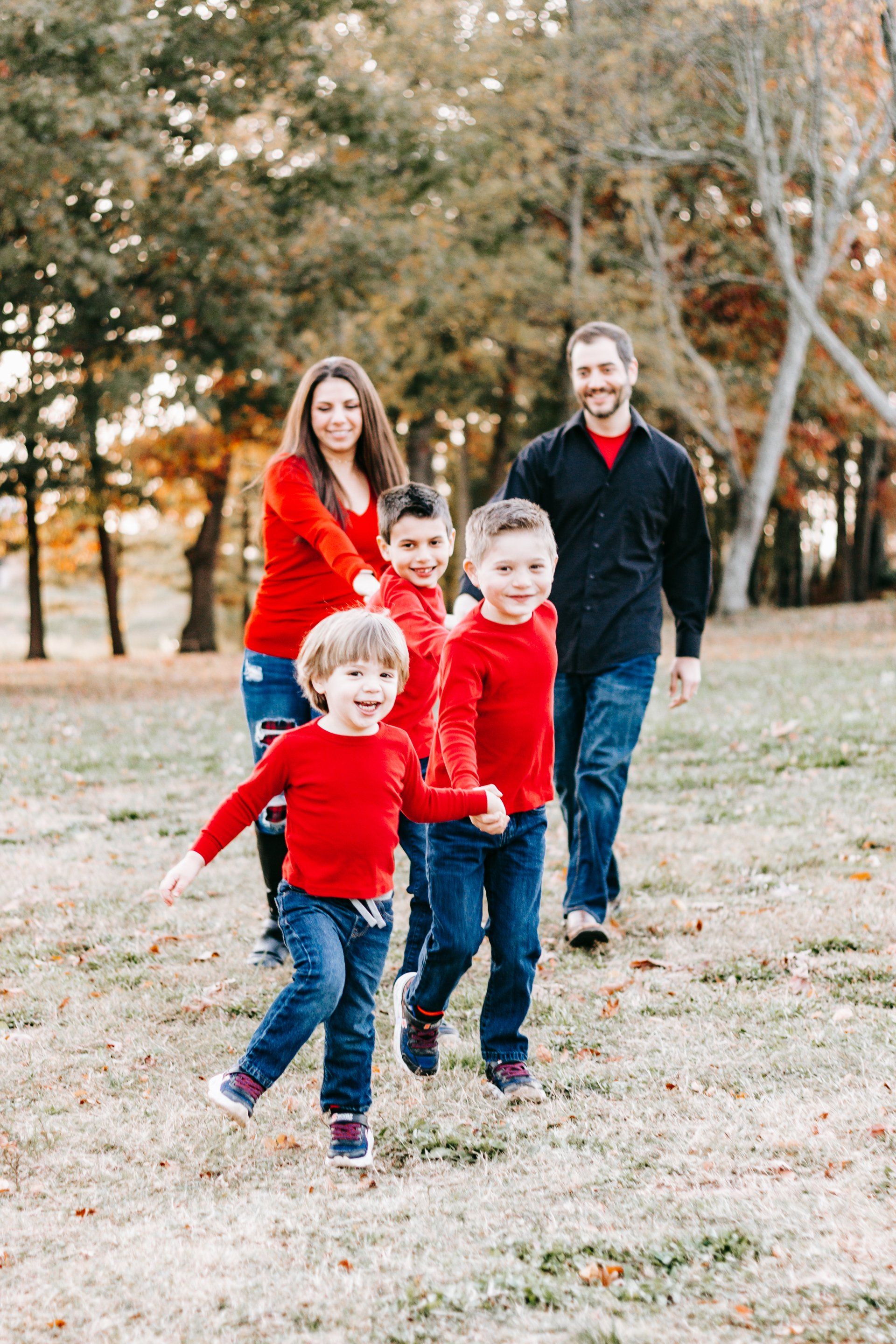 A family is running through a field in a park.