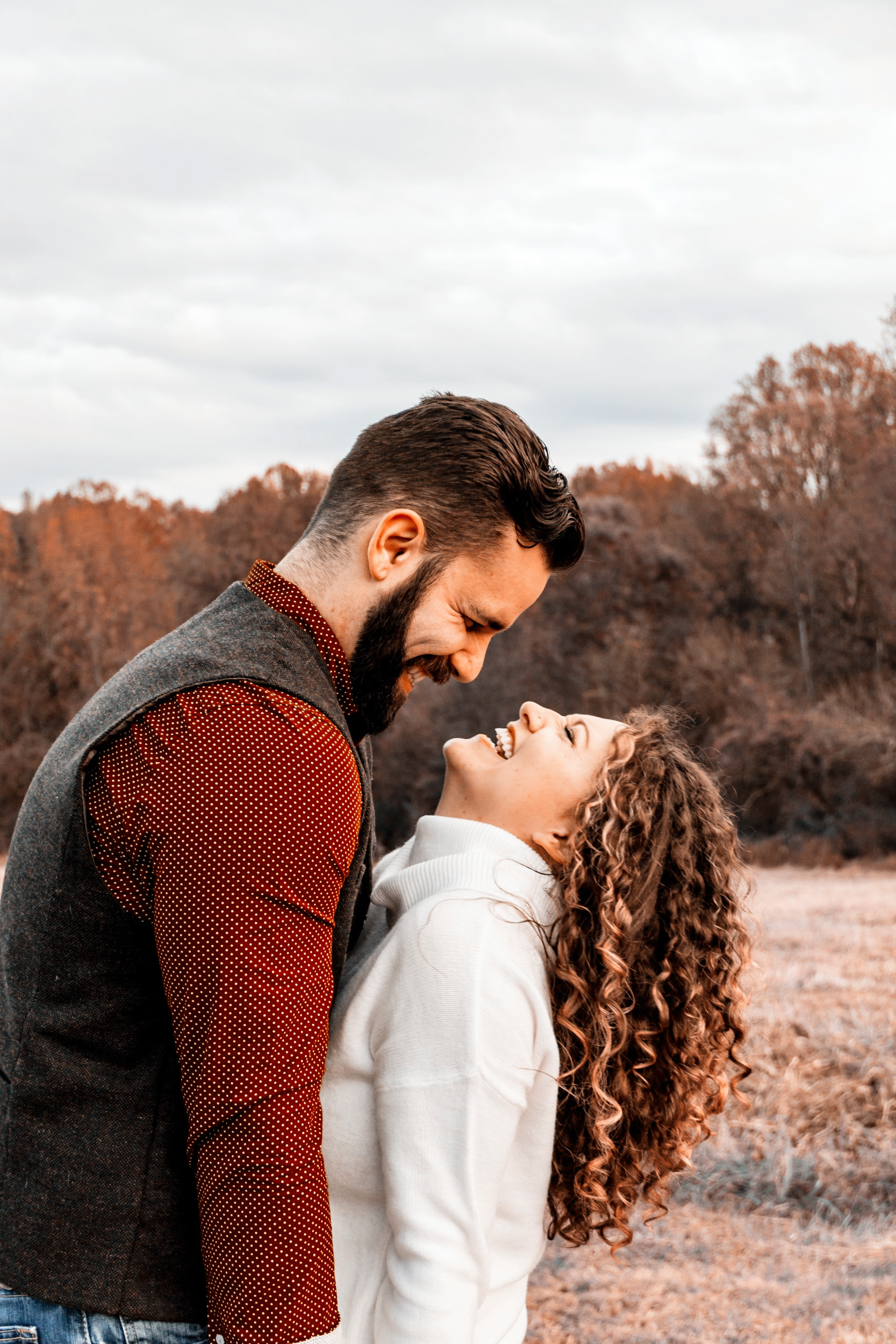 A man and a woman are looking at each other in a field.