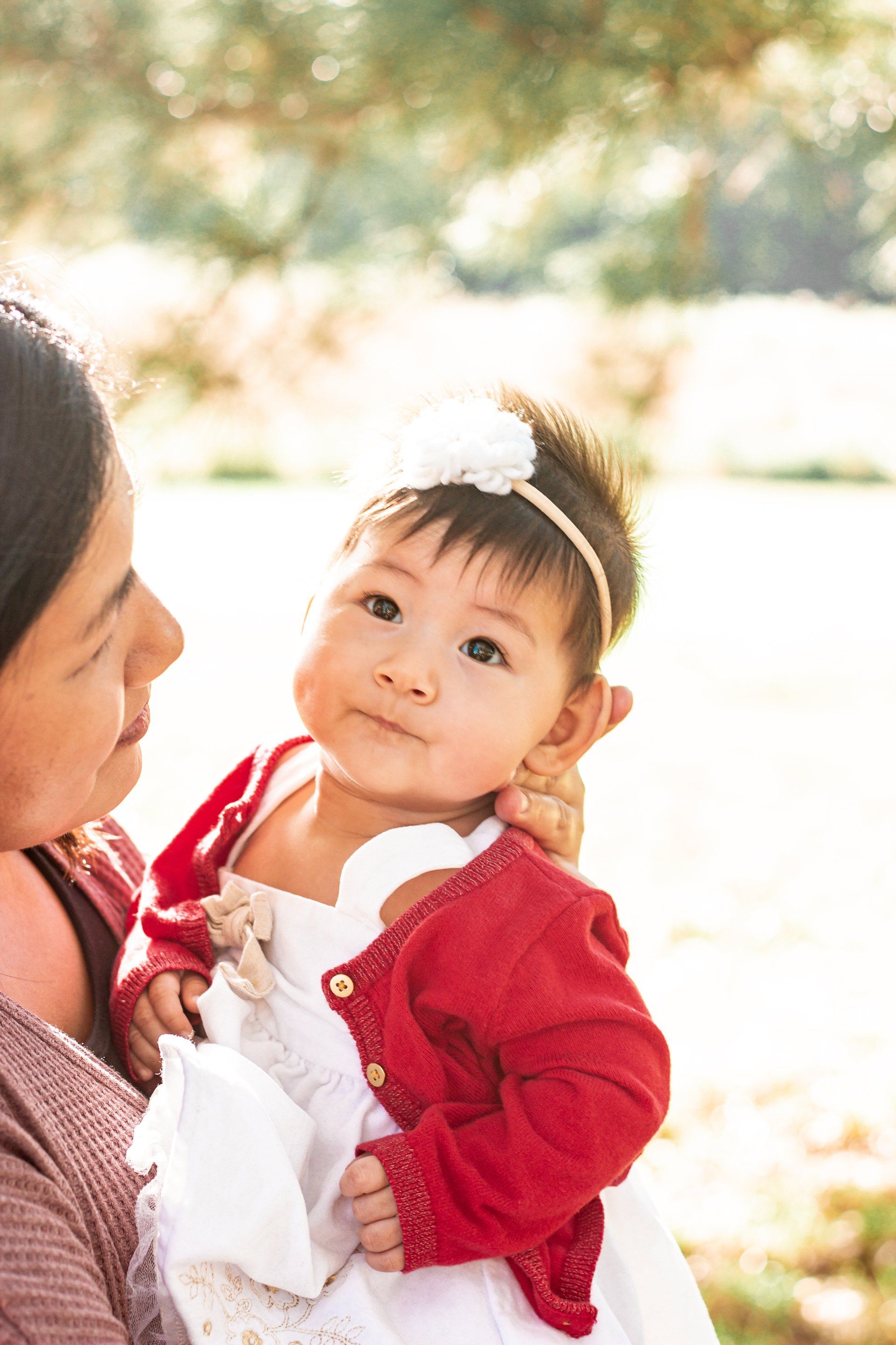 A woman is holding a baby girl in her arms.