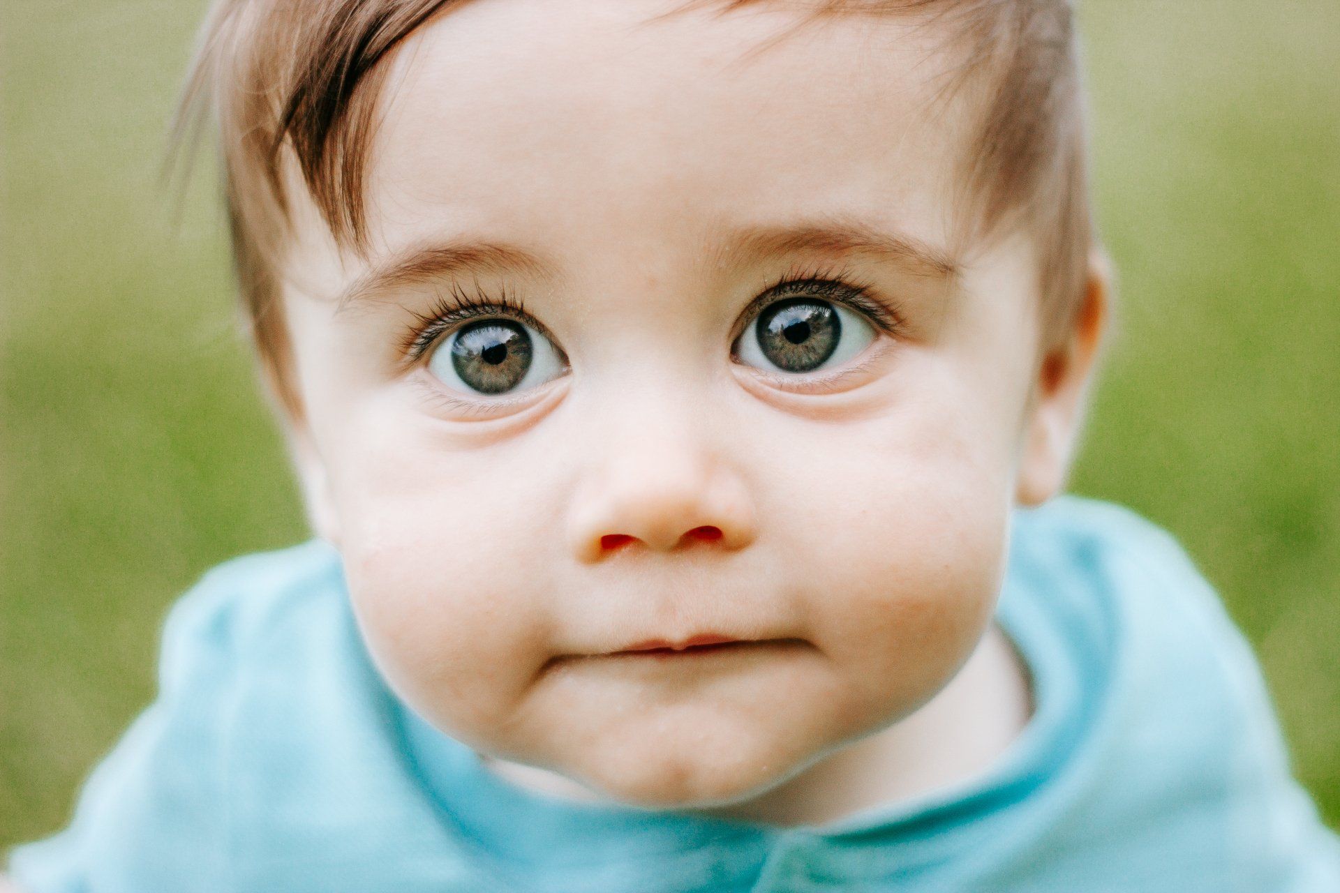 A close up of a baby 's face looking at the camera.