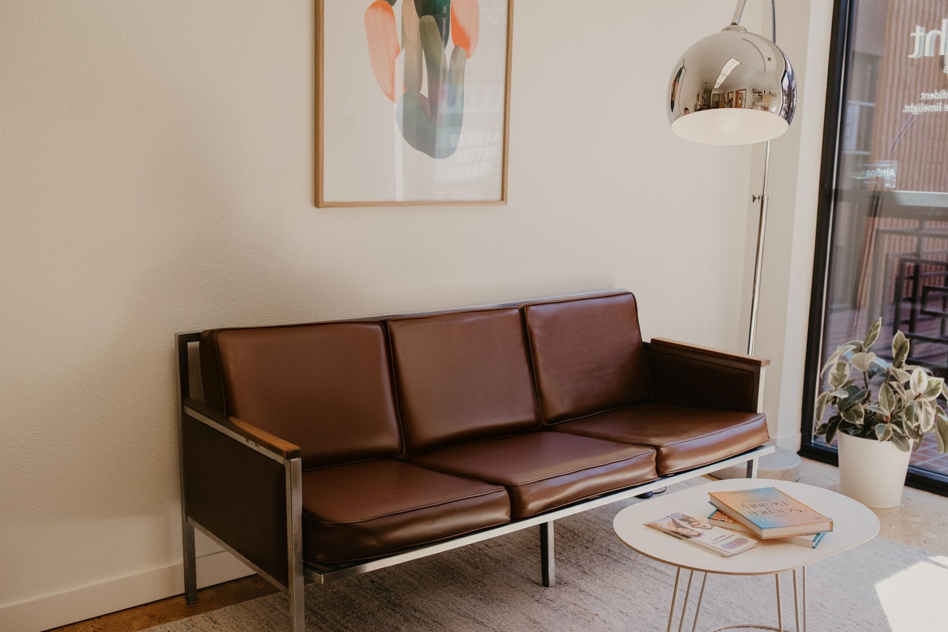 A brown couch is sitting in a living room next to a table.