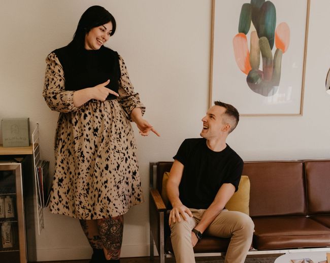A man and a woman are standing next to each other in a living room.