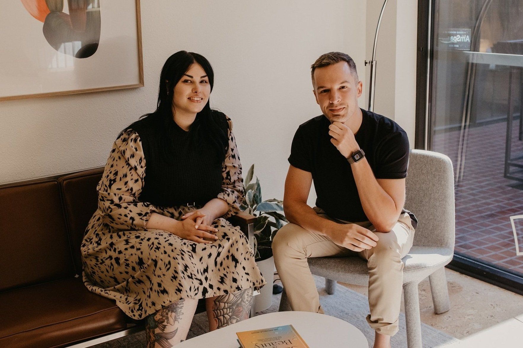 A man and a woman are sitting next to each other in a living room.