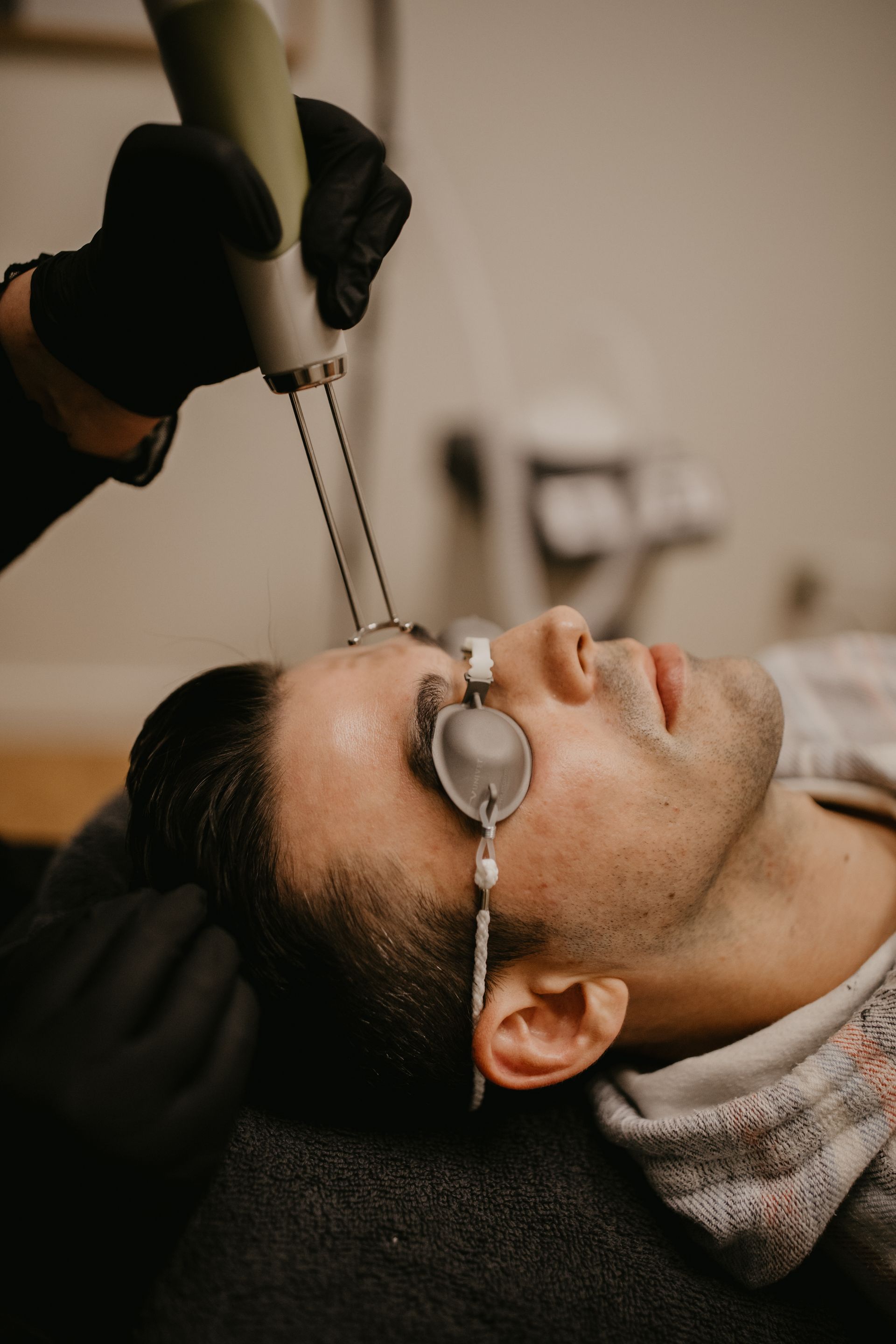 Smiling person with freckles and glowing skin against a white background.