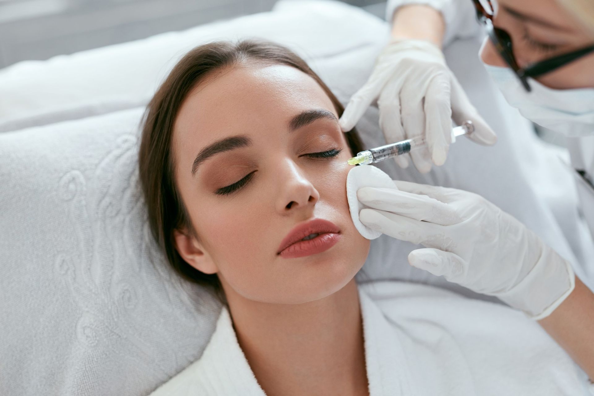 A woman is getting a botox injection in her face.