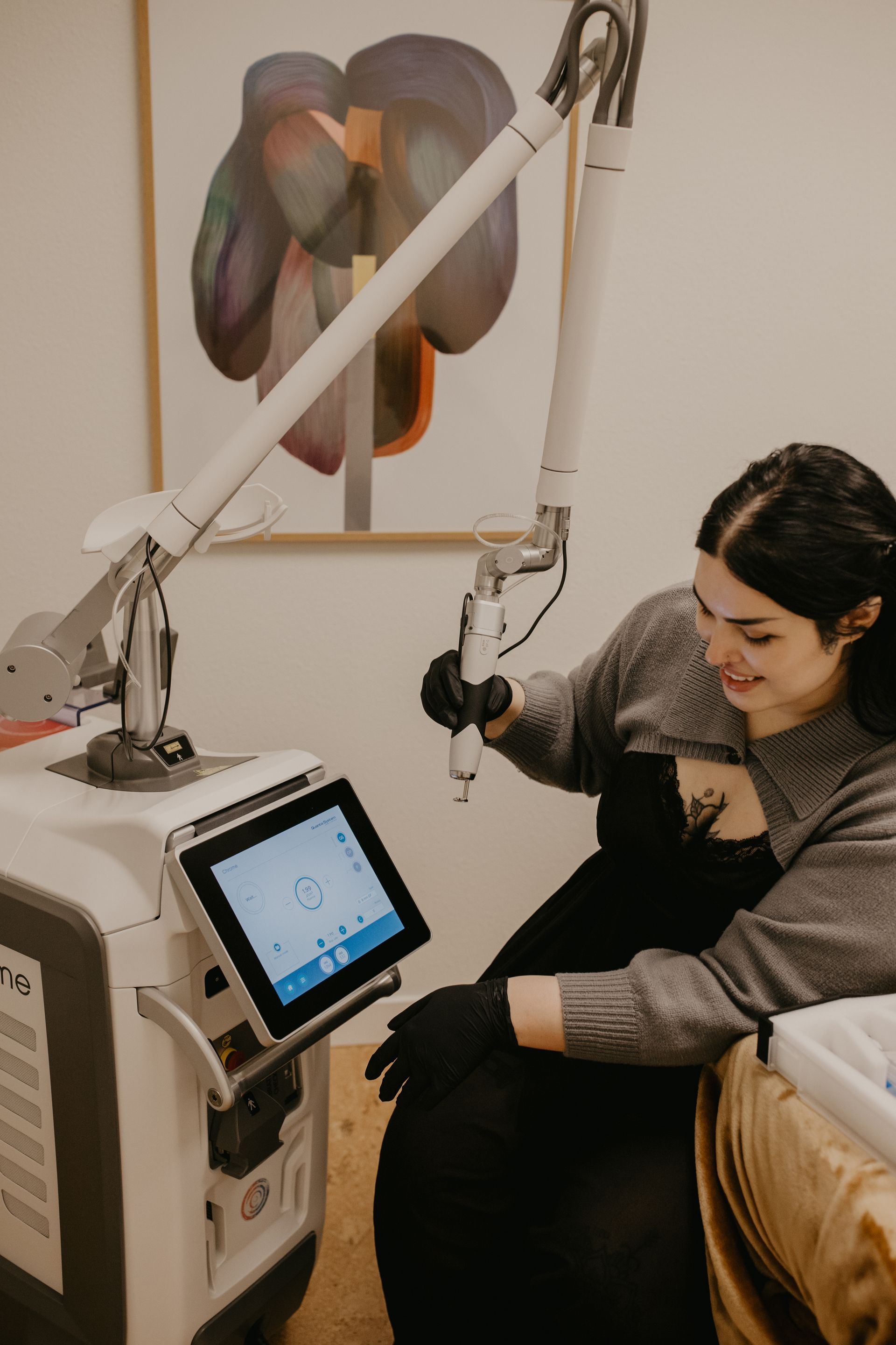 Laser tattoo removal on a person's arm, detail shot. Laser held to skin, removing the black bird tattoo.