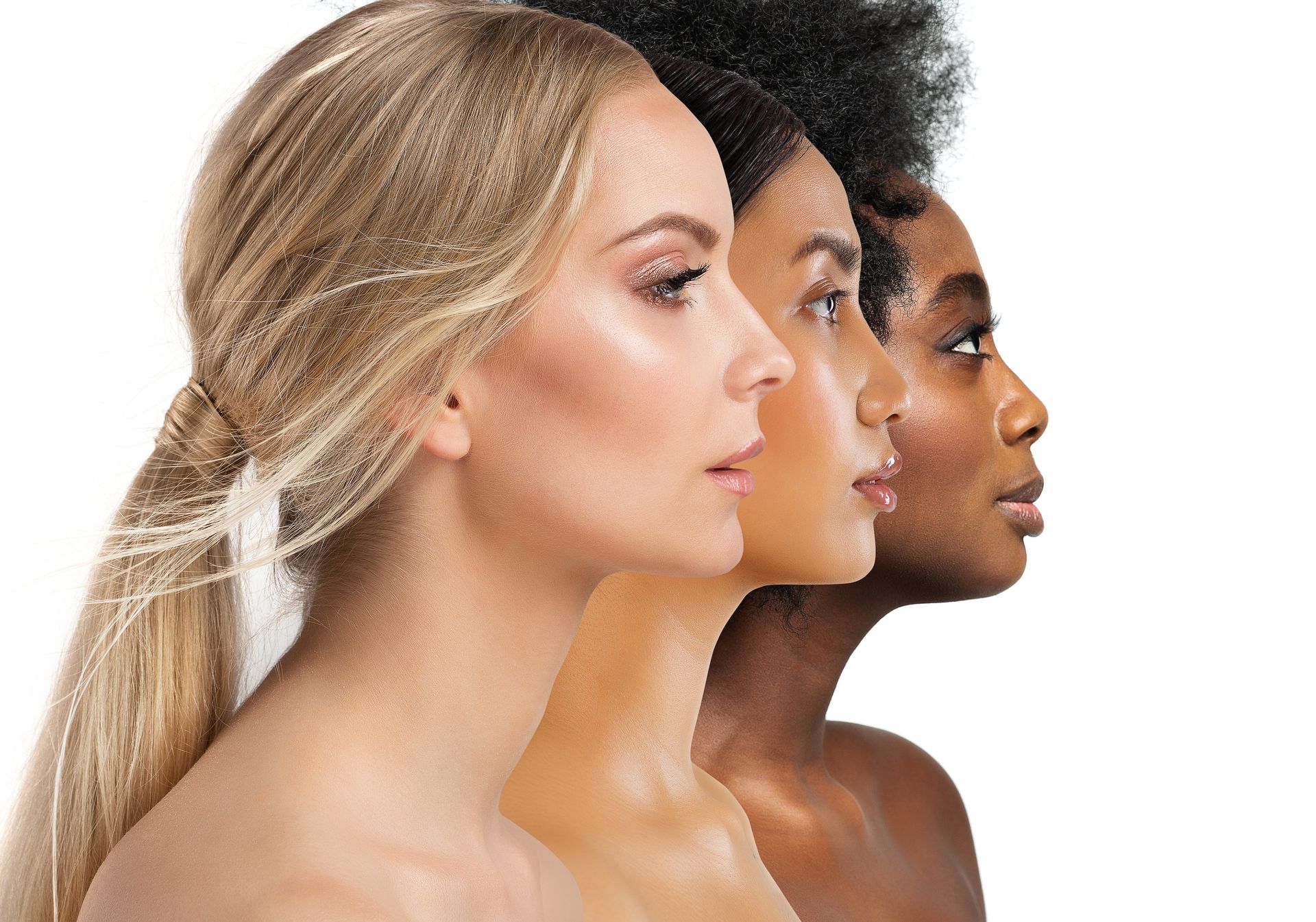 Three women of different races are standing next to each other on a white background.