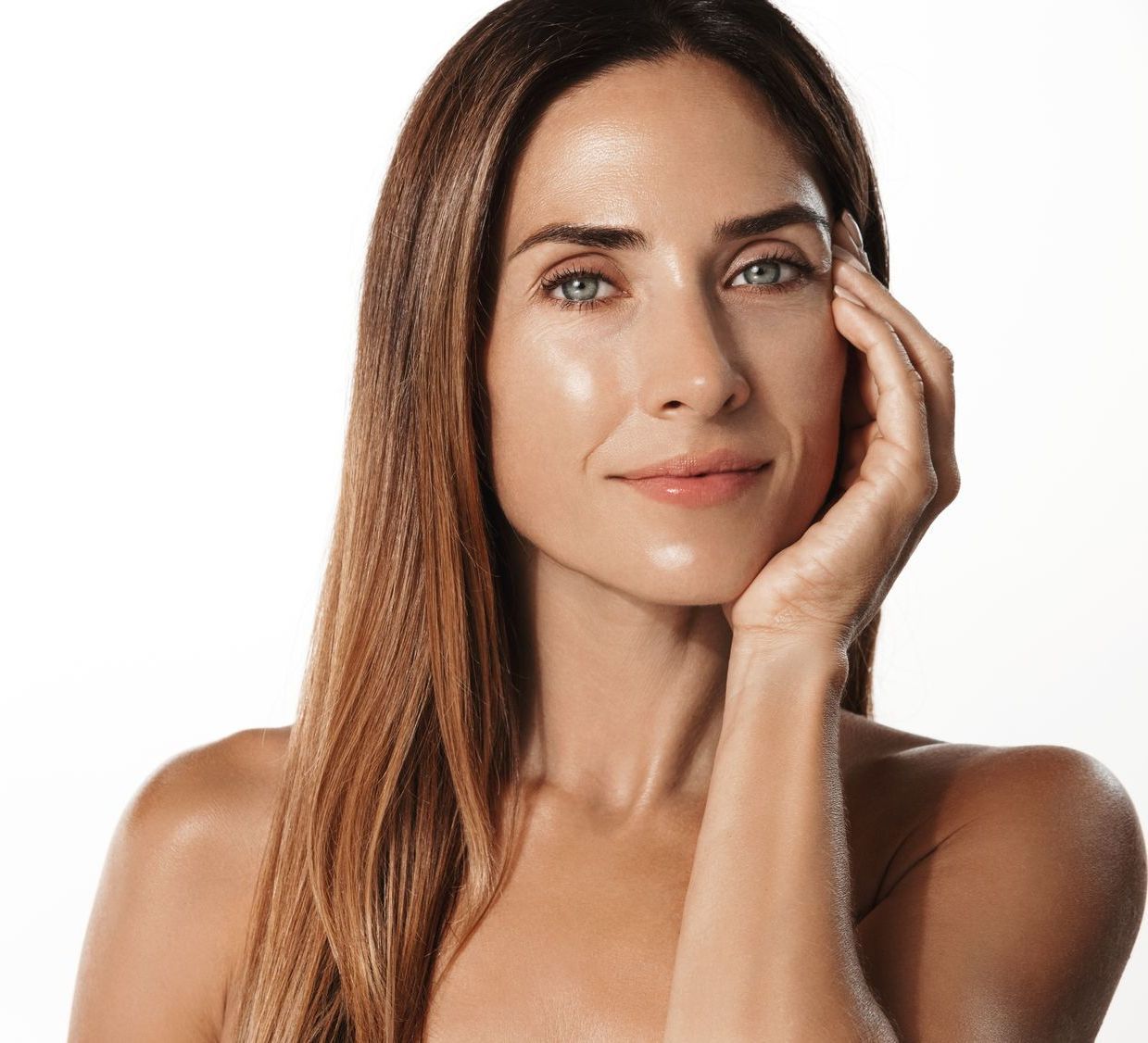 A woman with long hair is holding her hand to her face