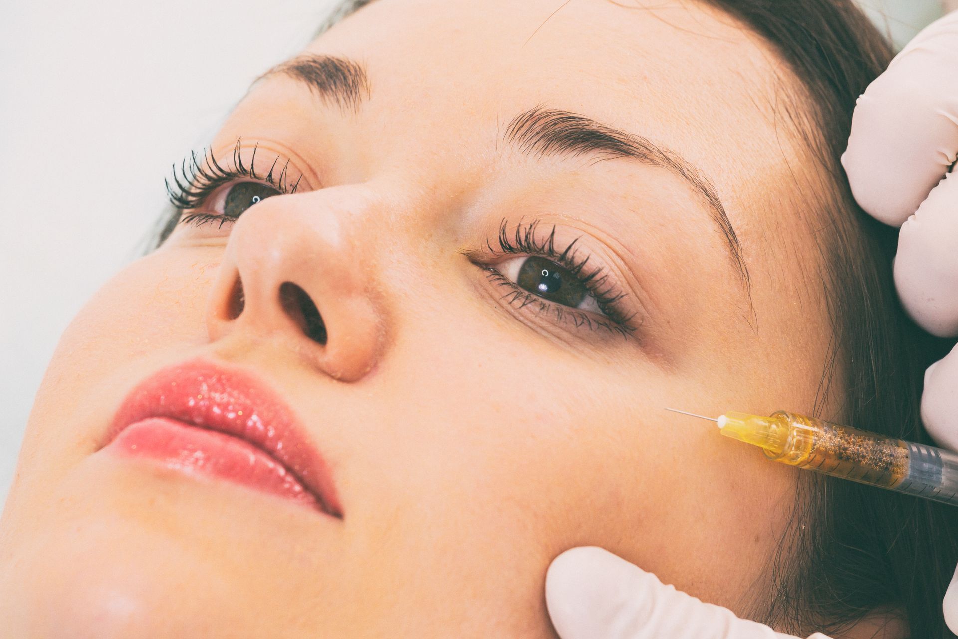 A woman is getting a botox injection in her face.