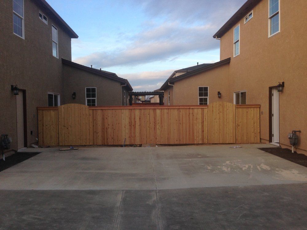 Apartment courtyard with a wooden privacy fence and concrete ground between two buildings