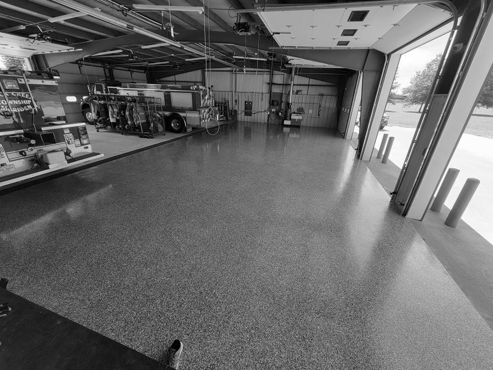 A black and white photo of a fire truck in a garage.