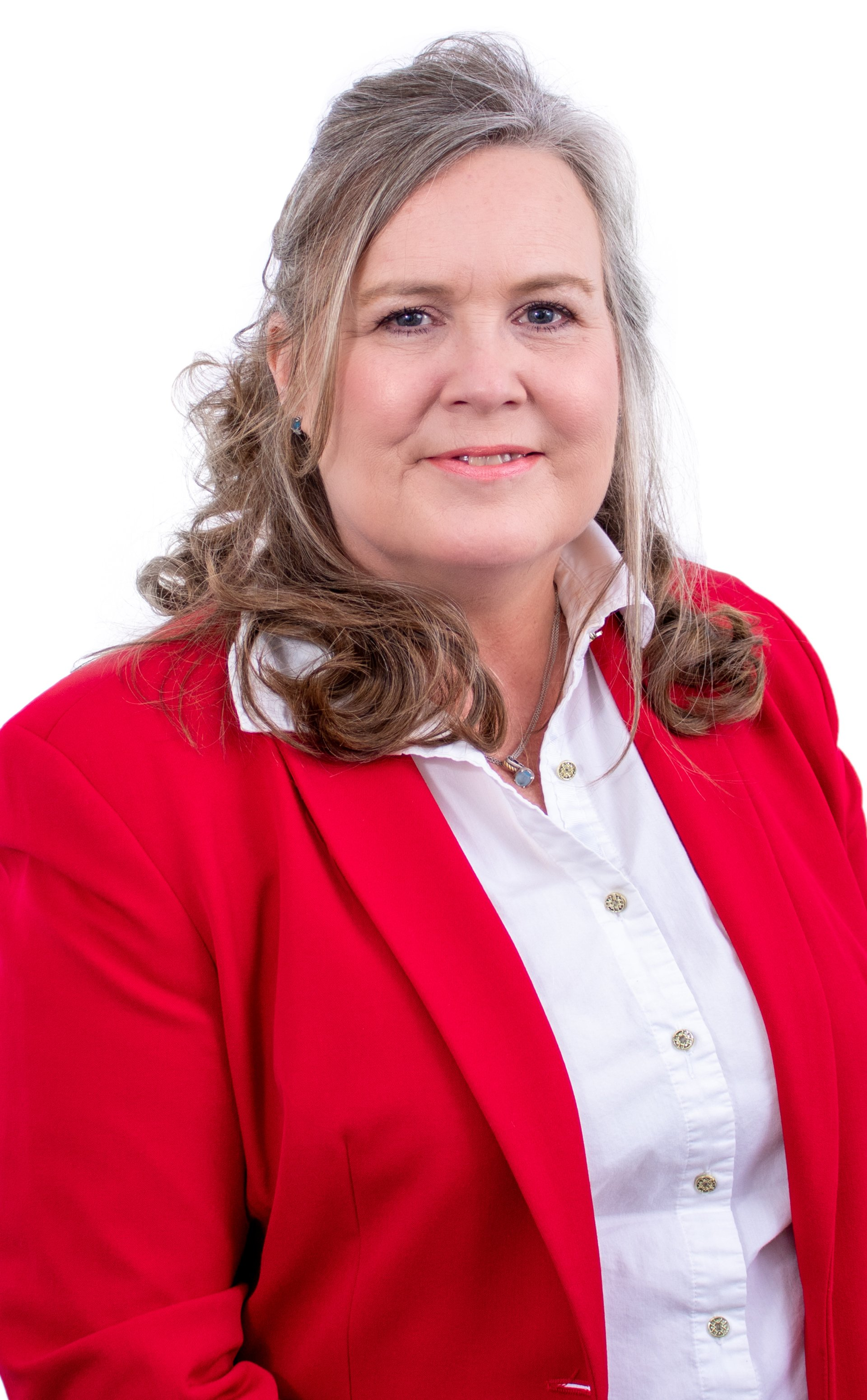 Woman with curly gray hair, wearing a red blazer and white shirt, smiling.