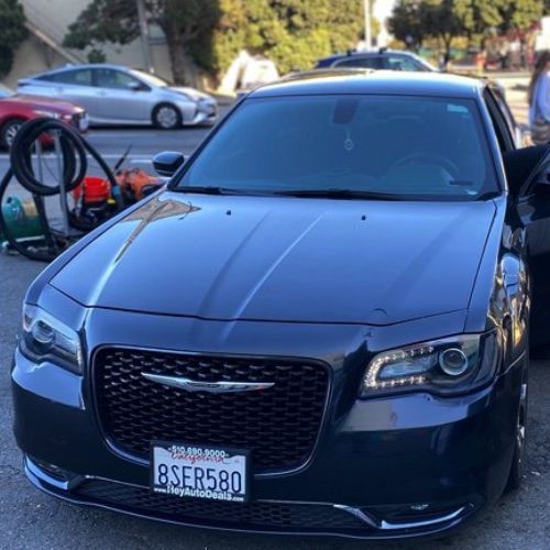 A black car with a license plate that says bser580 is parked in a parking lot.