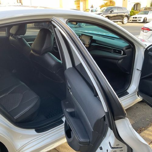 The inside of a white car with the door open.
