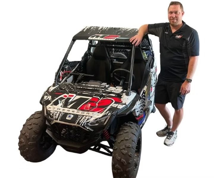 man standing next to atv