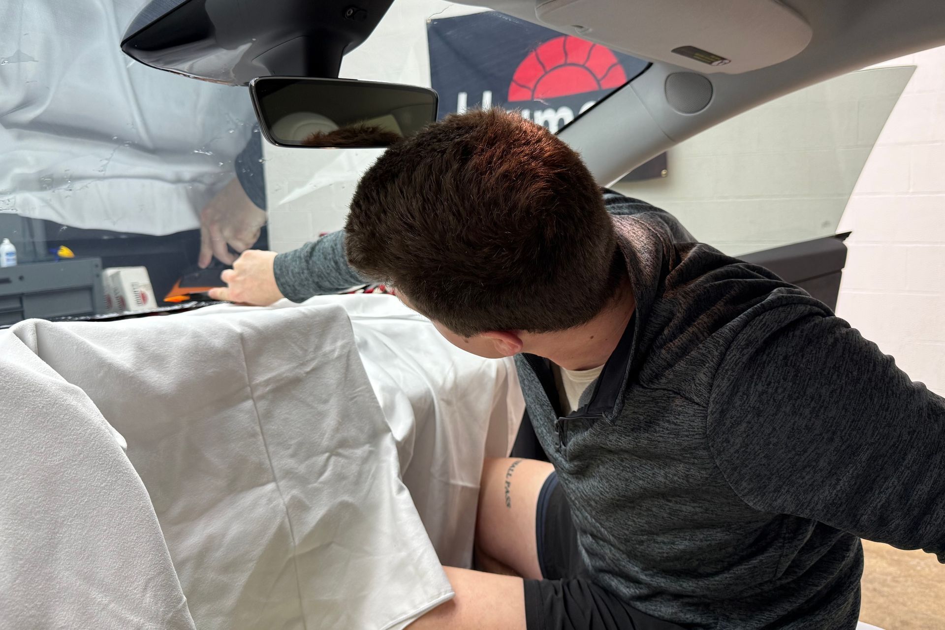 A man is sitting in the back seat of a car.