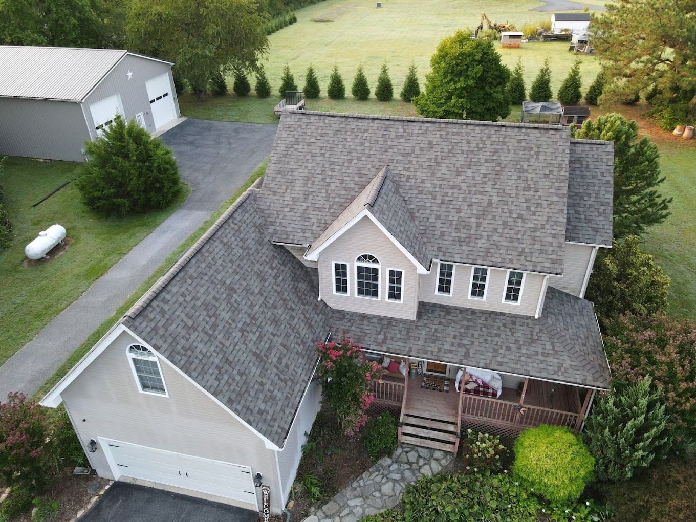 An aerial view of a house with a gray roof and a garage.