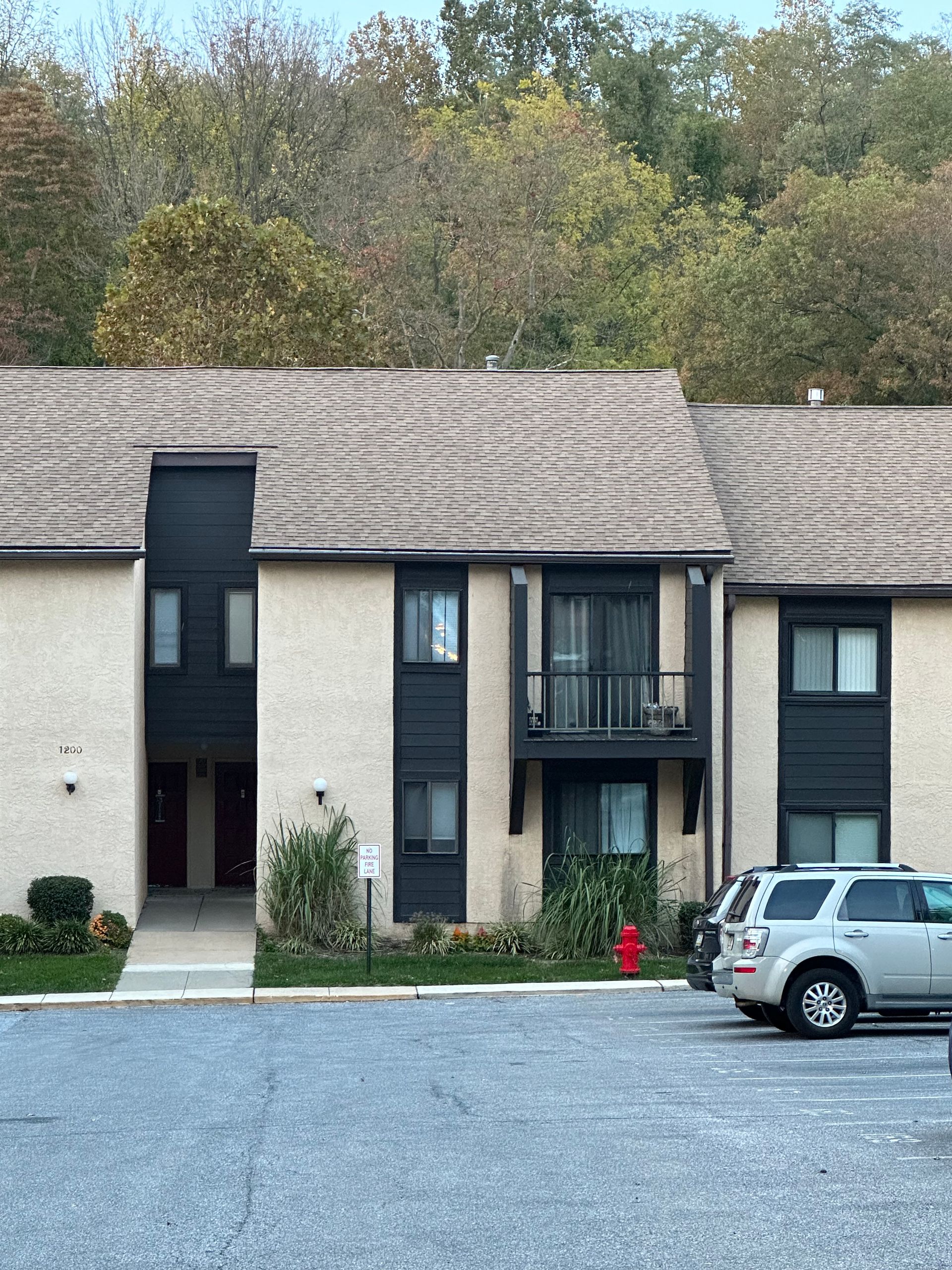 A row of apartment buildings with cars parked in front of them