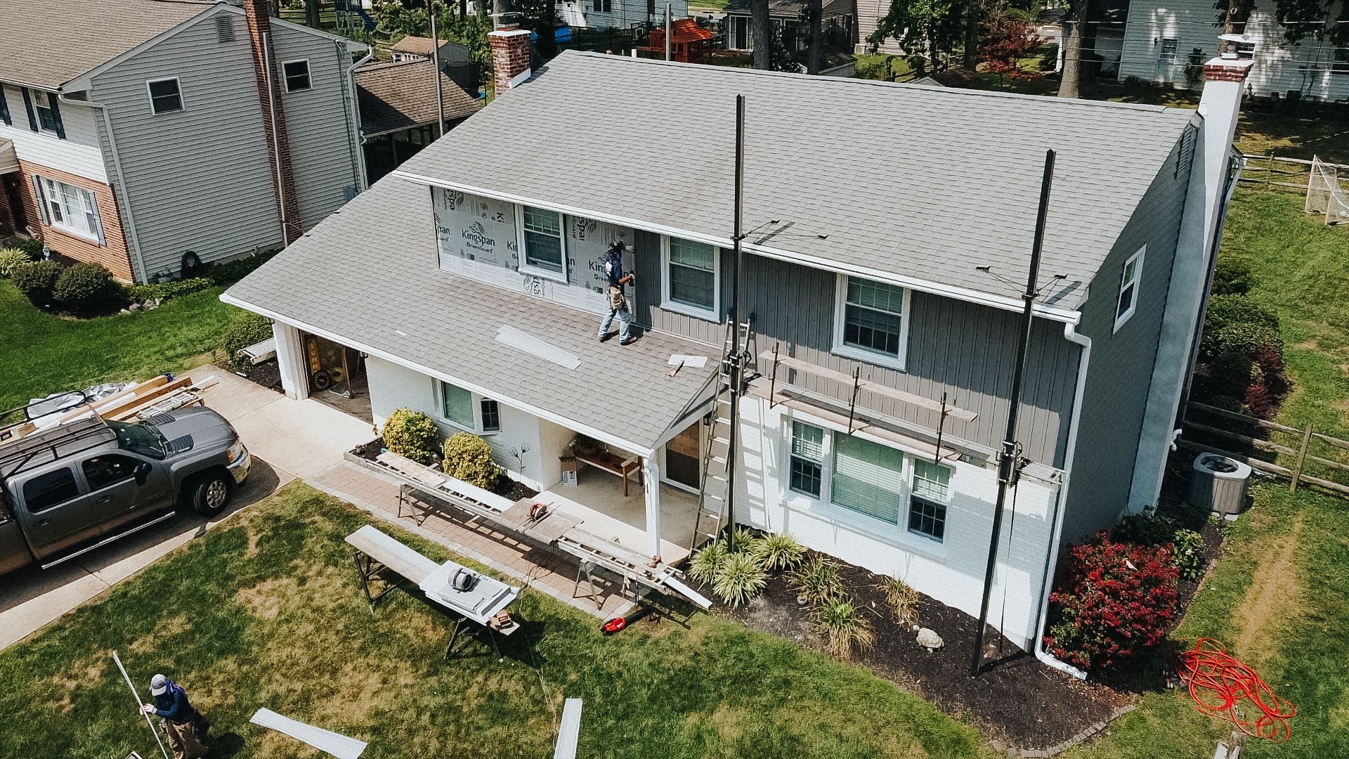 An aerial view of a house under construction with a truck parked in front of it.