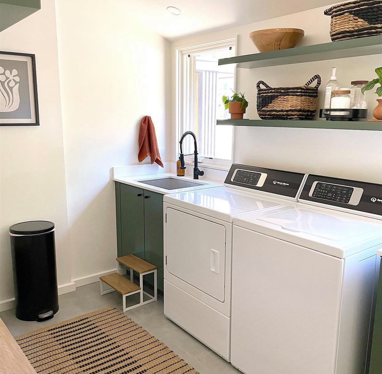 Uma lavanderia com lavadora e secadora e pia.