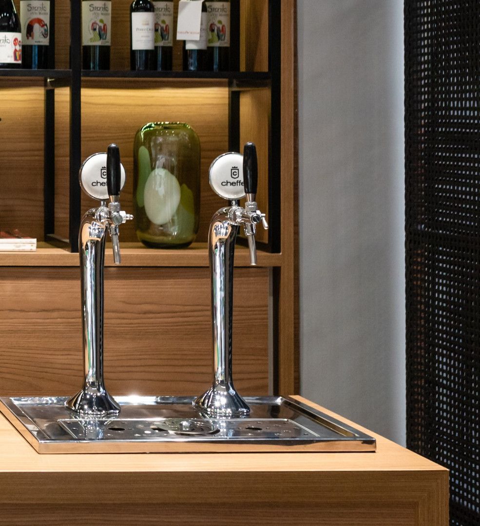 Duas torneiras de cerveja estão sobre uma mesa de madeira