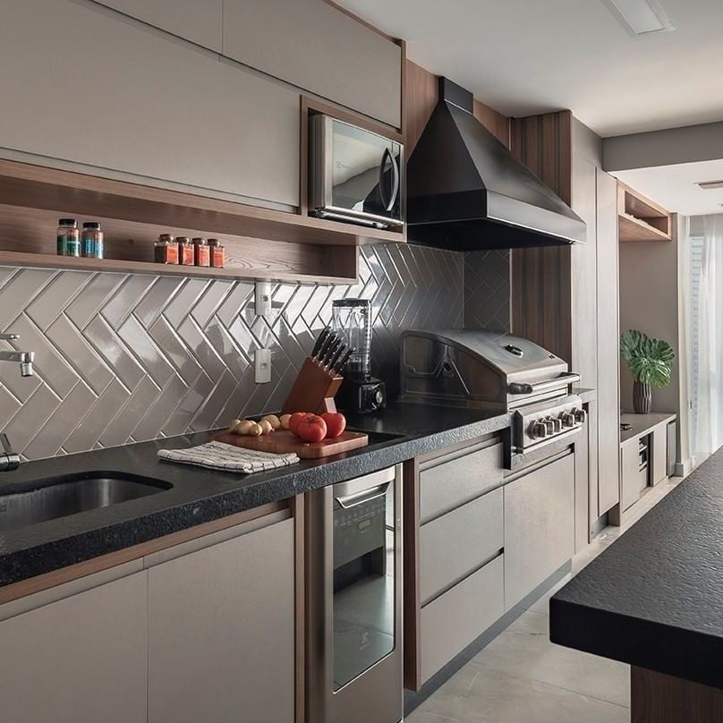 Uma cozinha com pia, forno, micro-ondas e churrasqueira