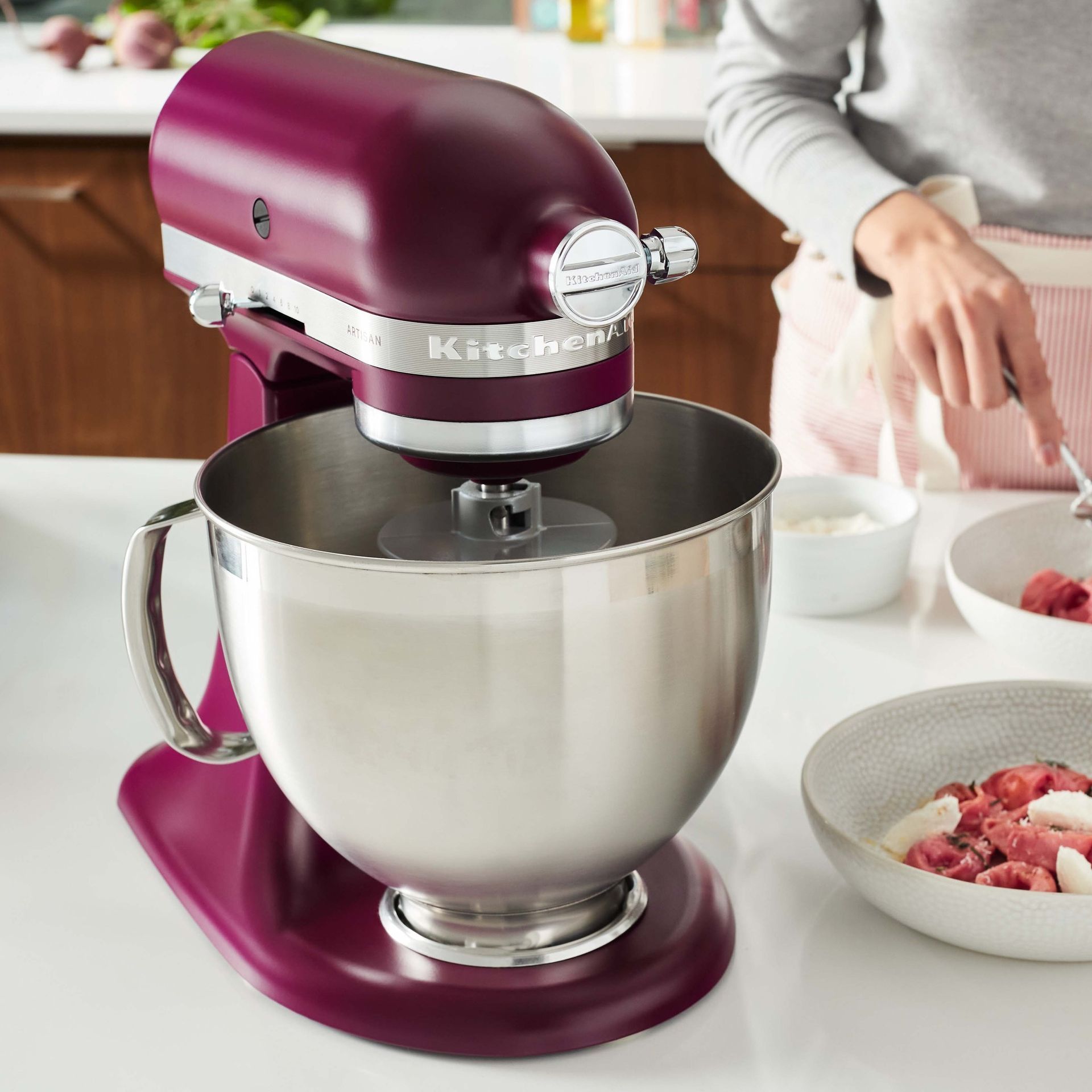 Uma batedeira kitchenaid roxa está sobre um balcão