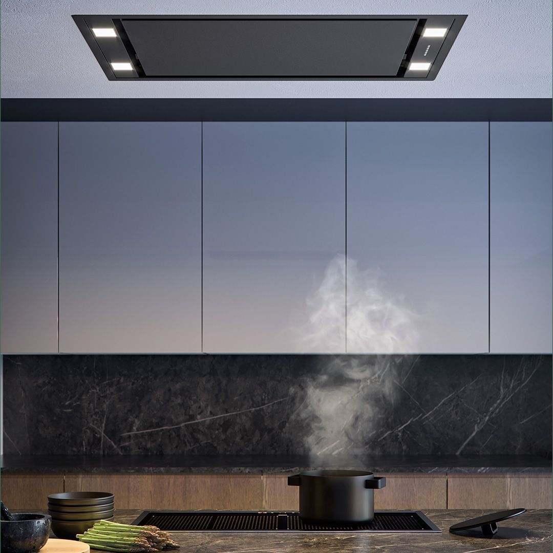 Uma panela está cozinhando no fogão de uma cozinha com fumaça saindo dela.