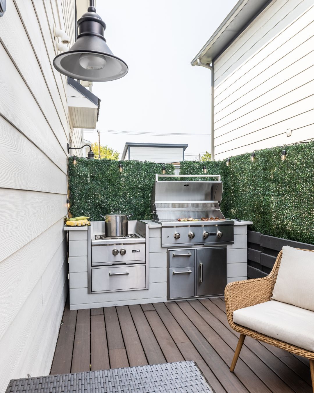 Um pátio com churrasqueira e cadeira de vime