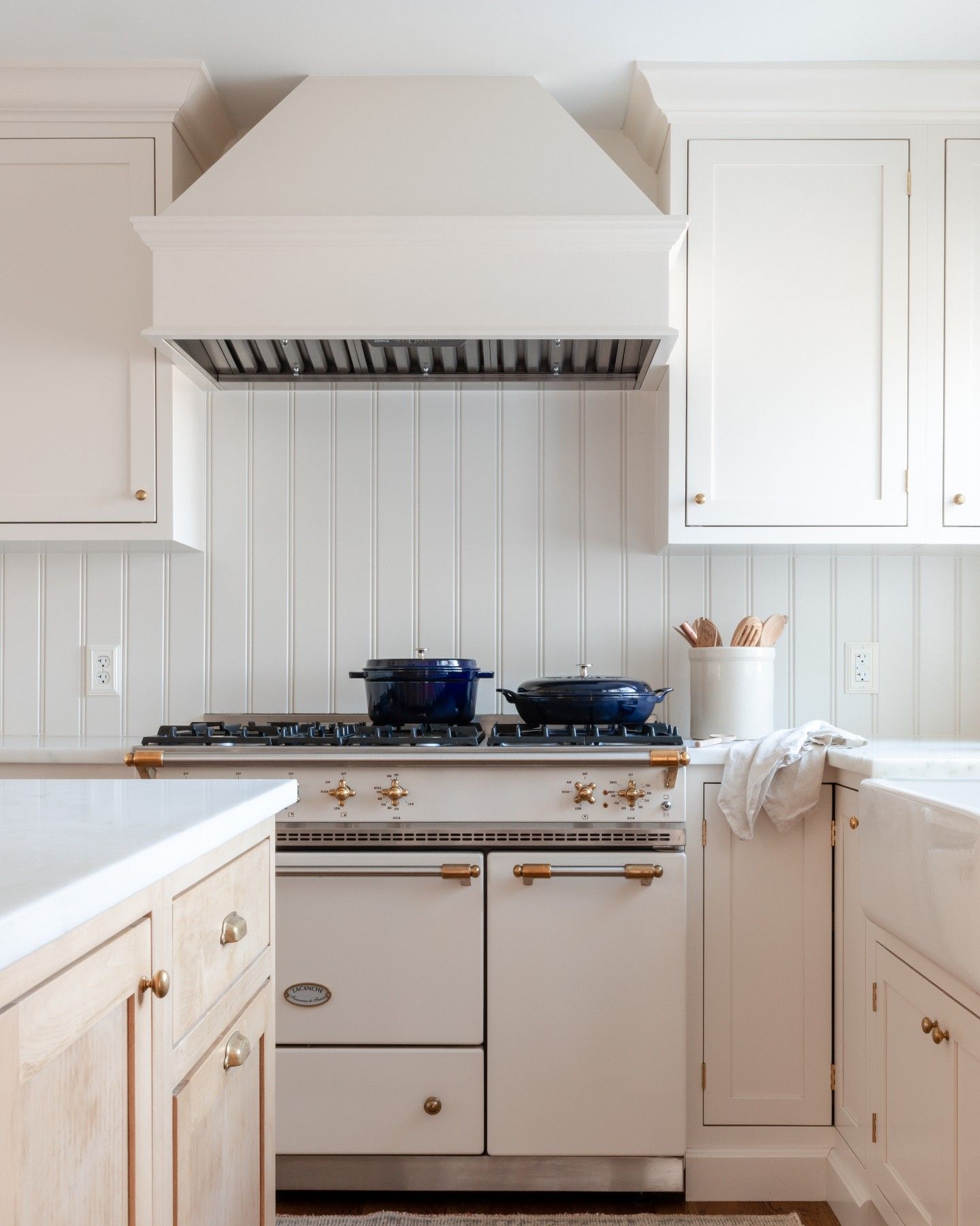 Uma cozinha com armários brancos e fogão com forno