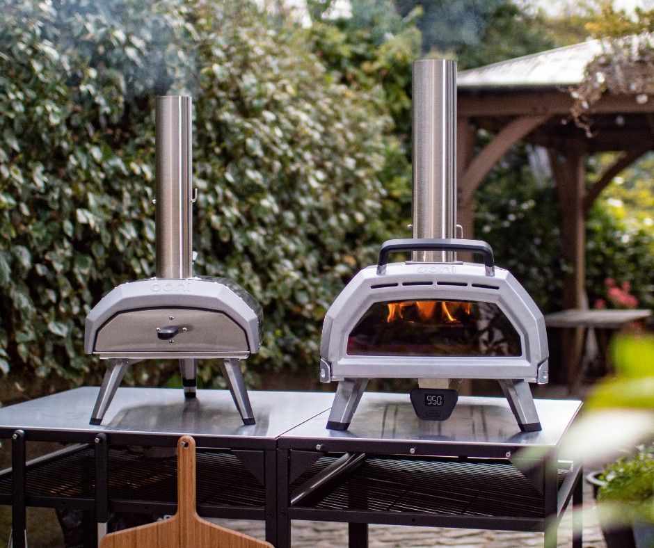 Dois fornos de pizza estão em cima de uma mesa.