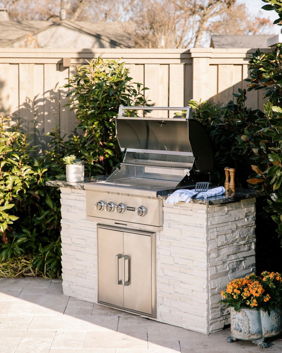 Uma grelha de aço inoxidável está em cima de um balcão de tijolos brancos.