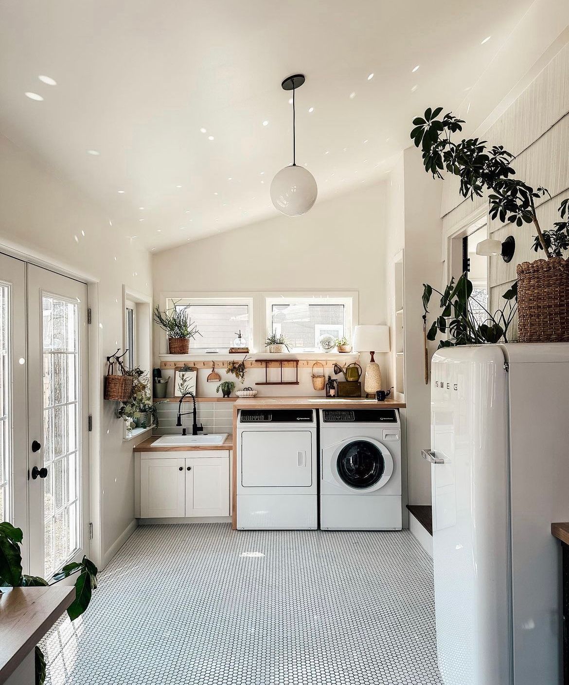 Uma lavanderia com lavadora e secadora e geladeira.