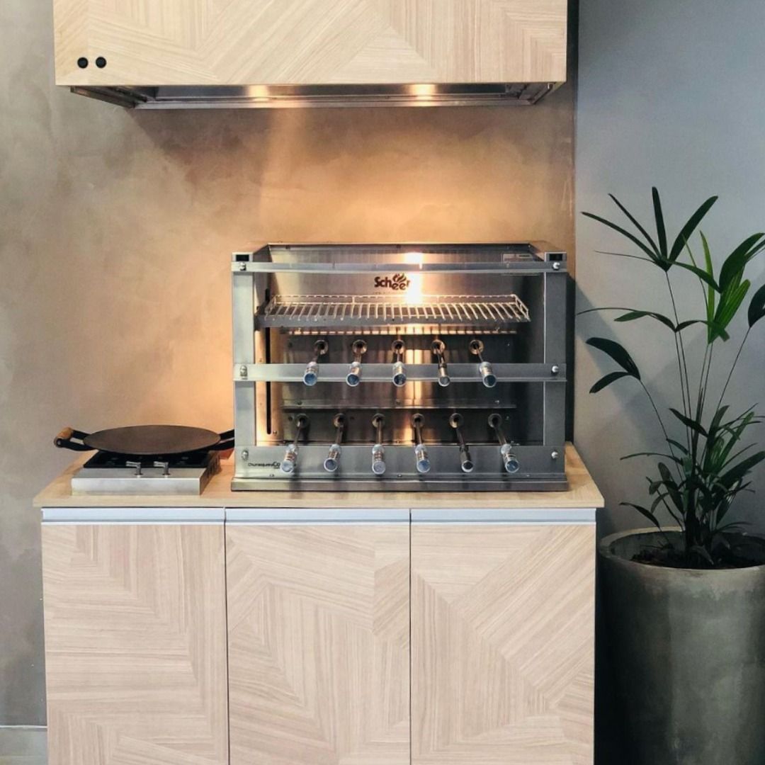 Uma grelha de aço inoxidável está em cima de um armário de madeira.