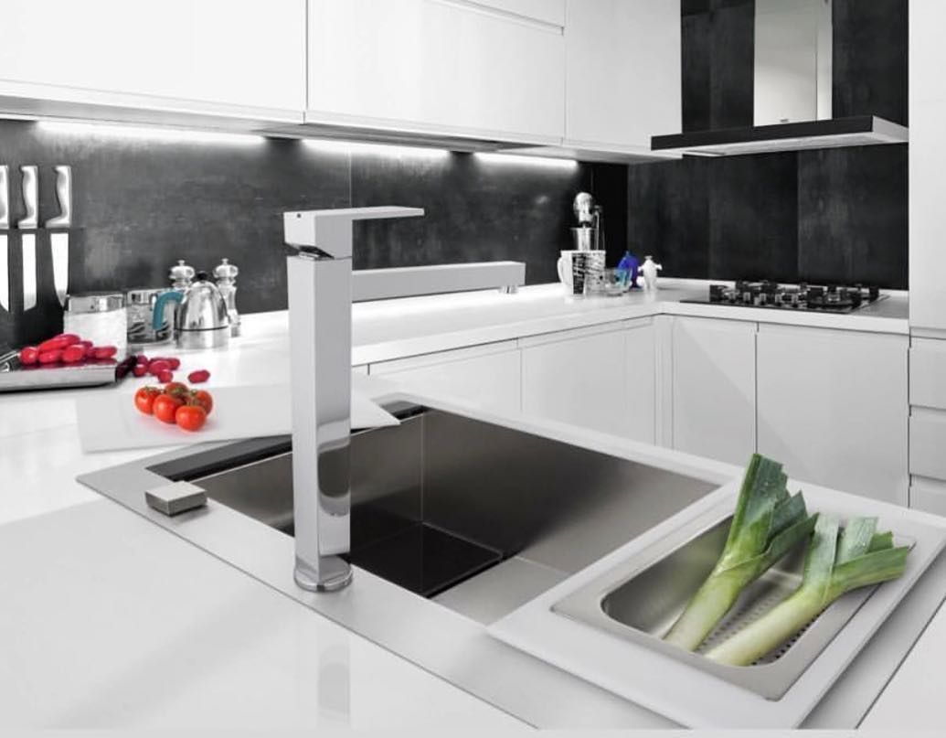 Uma cozinha com pia e legumes no balcão