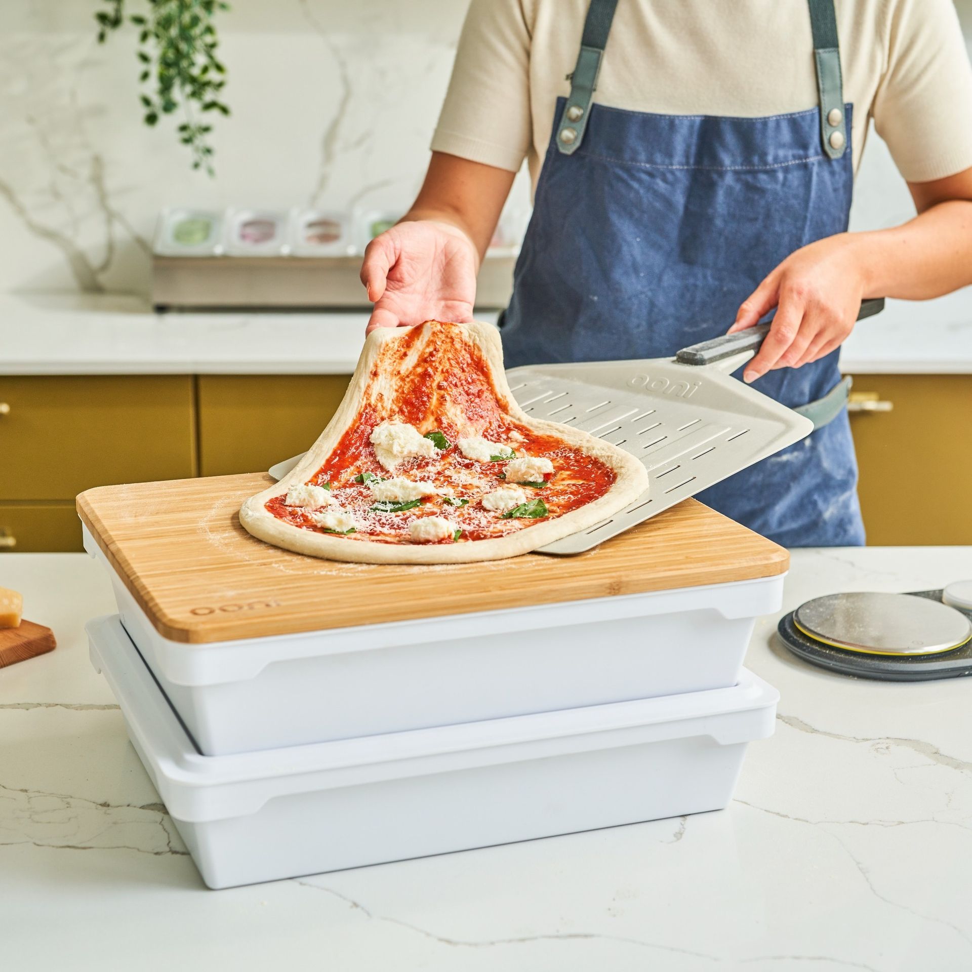 Uma pessoa está tirando uma pizza de uma panela sobre uma tábua de madeira.