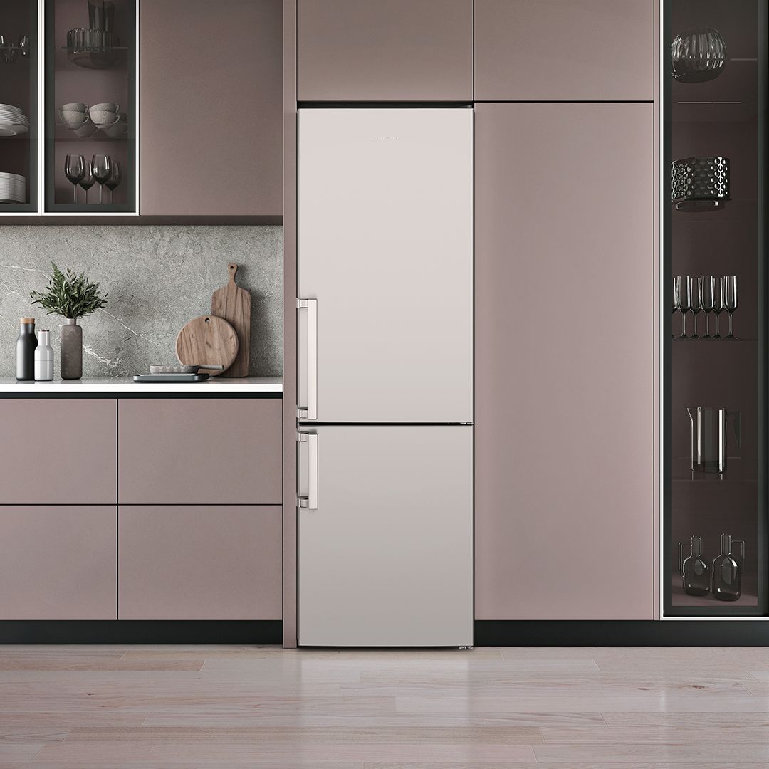 Uma cozinha com armários rosa e uma geladeira branca.