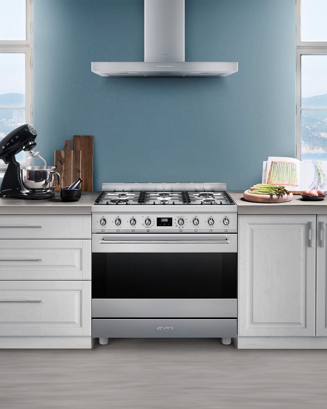 Uma cozinha com fogão e batedeira na bancada.