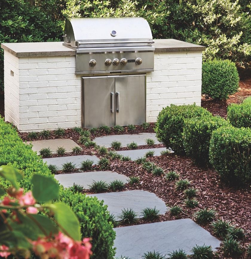 Uma grelha de aço inoxidável está em cima de um balcão de tijolos brancos