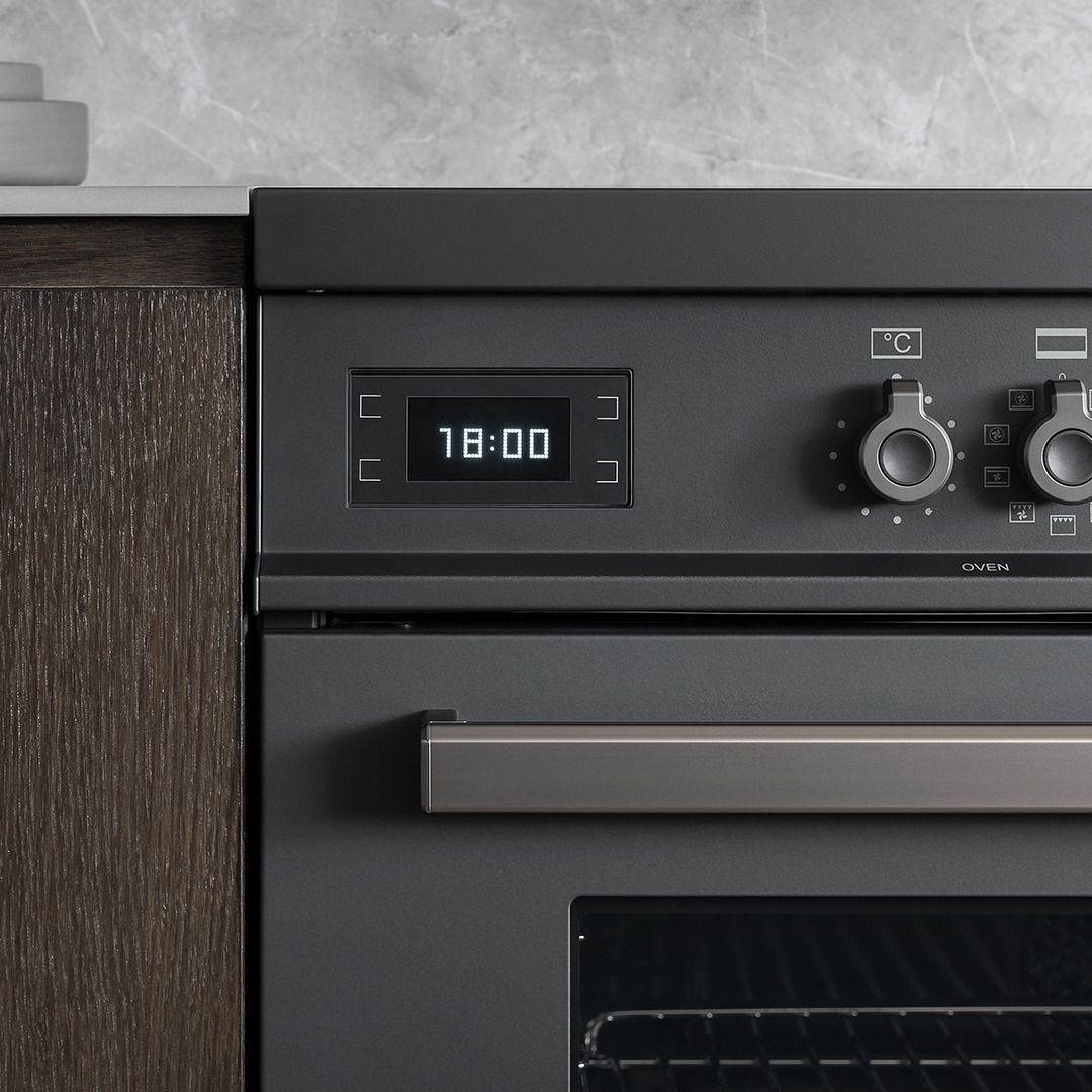 Um forno preto com display digital que marca 18:00