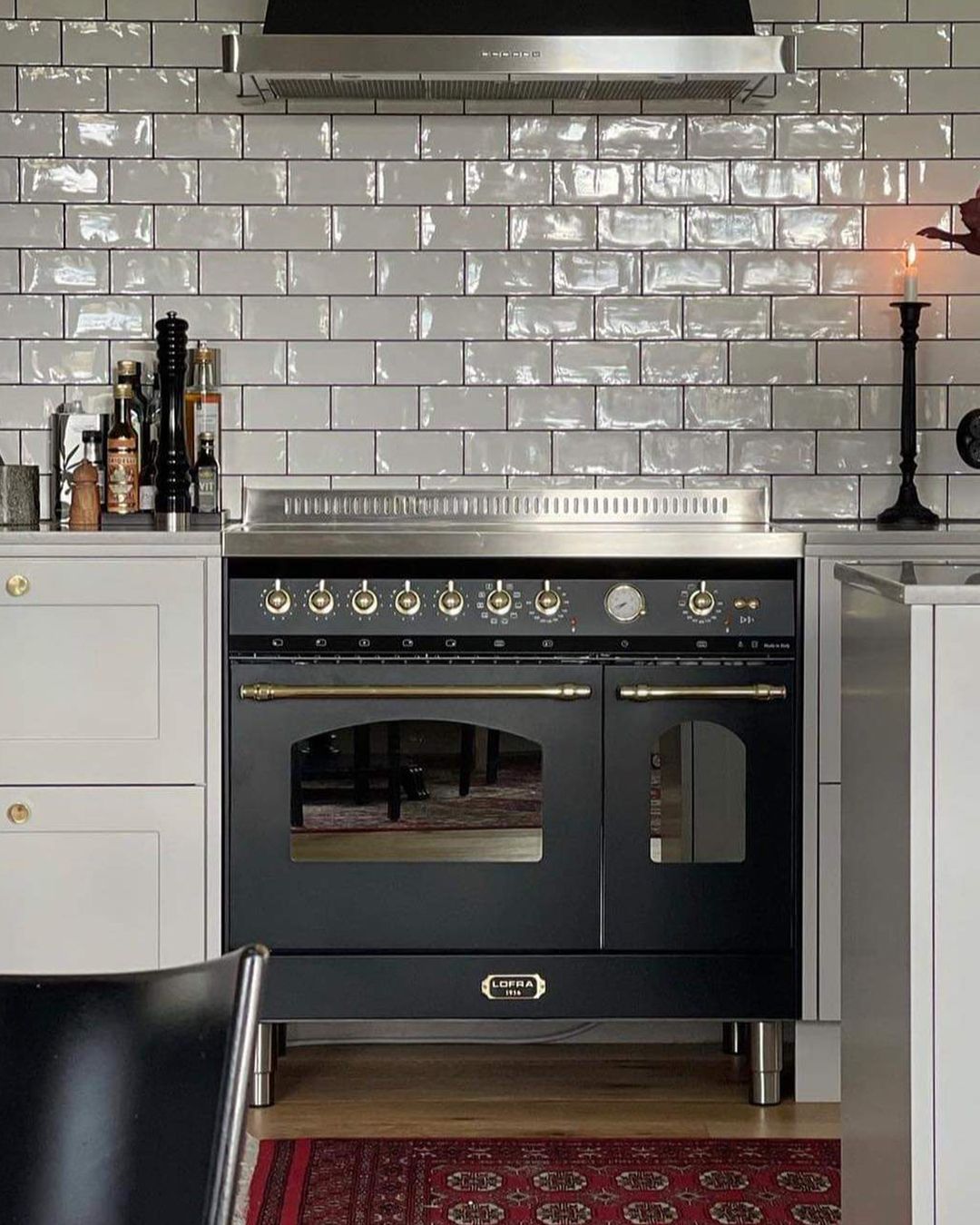 Uma cozinha com fogão preto e armários brancos