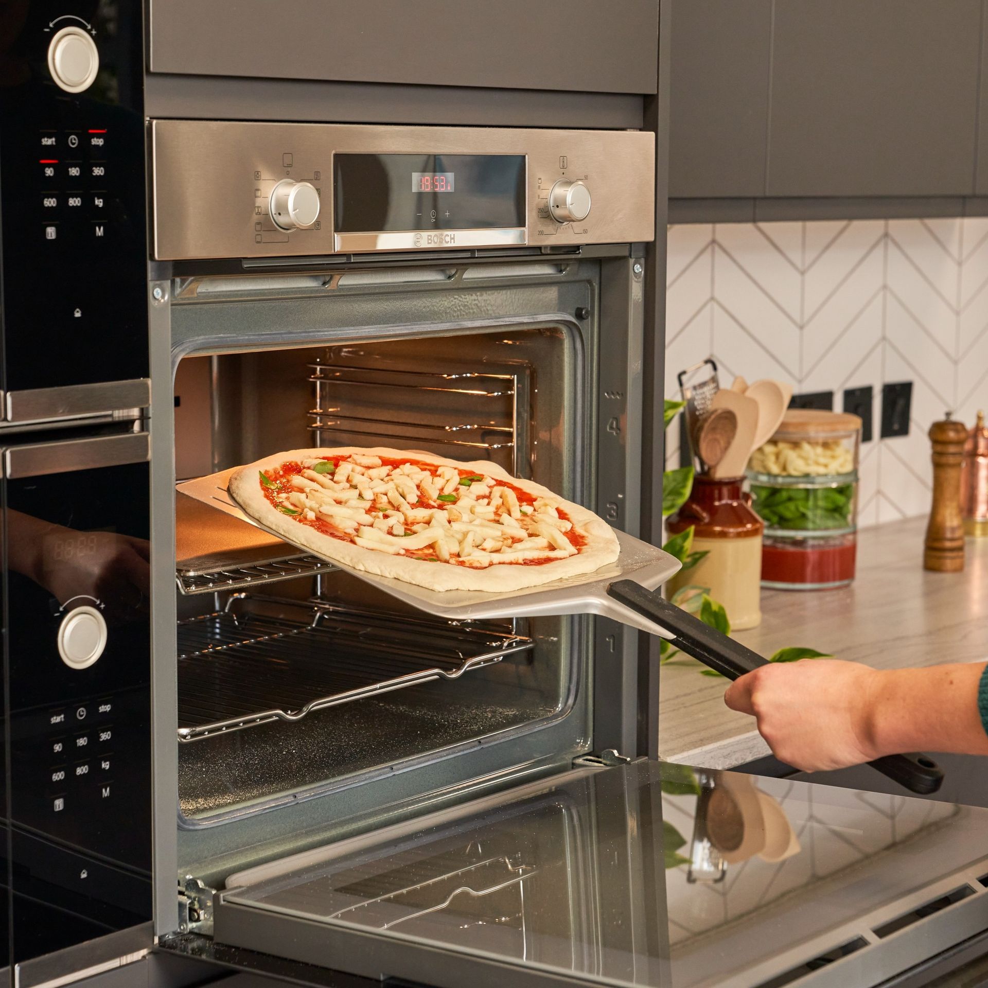 Uma pessoa está tirando uma pizza do forno
