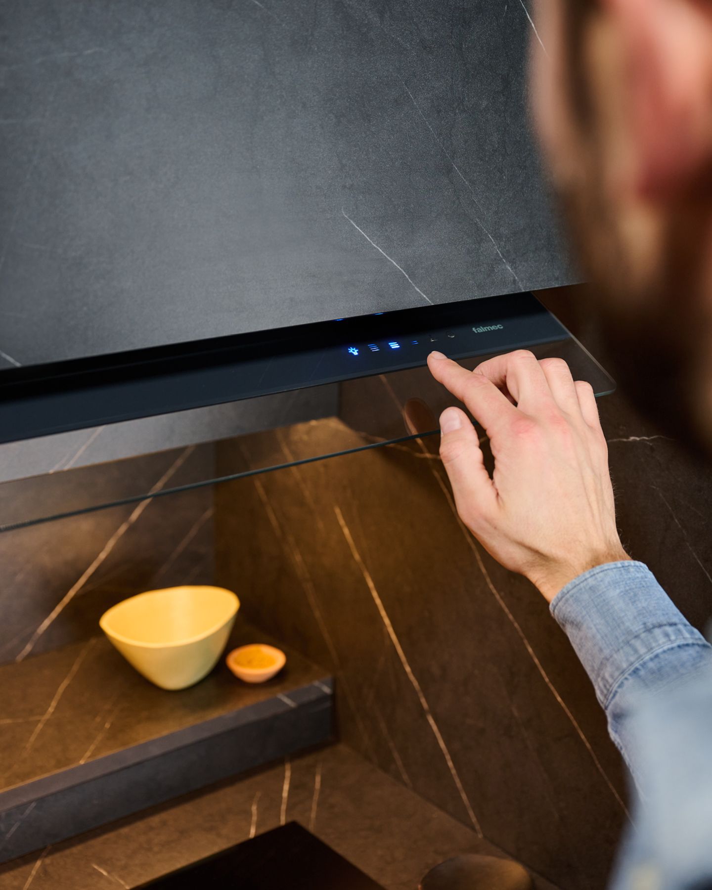 Um homem está apertando um botão no fogão de uma cozinha.