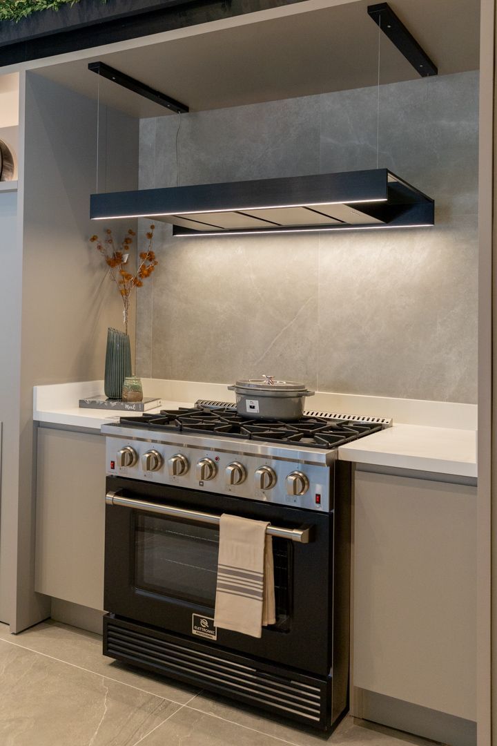 Um fogão preto está em uma cozinha ao lado de um balcão.