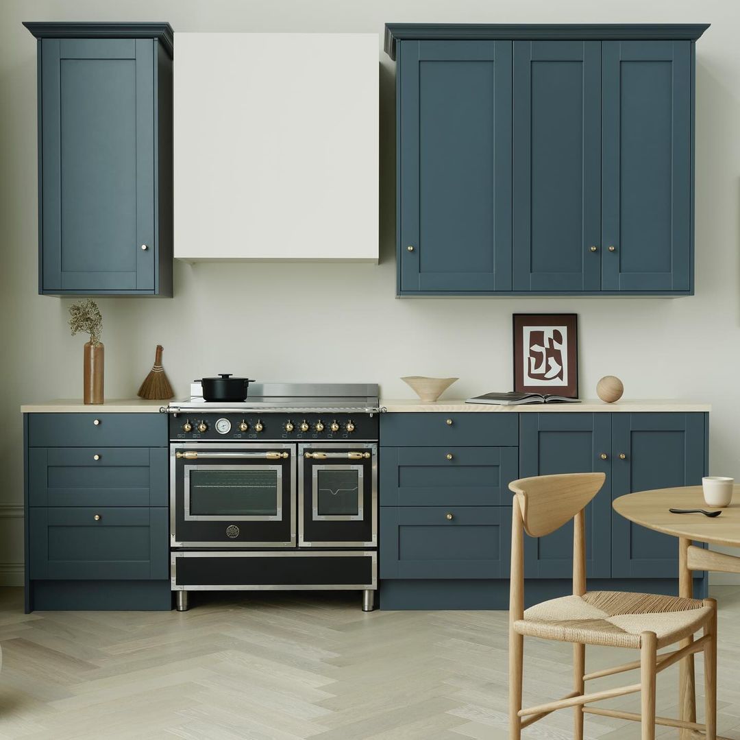 Uma cozinha com armários azuis e fogão preto
