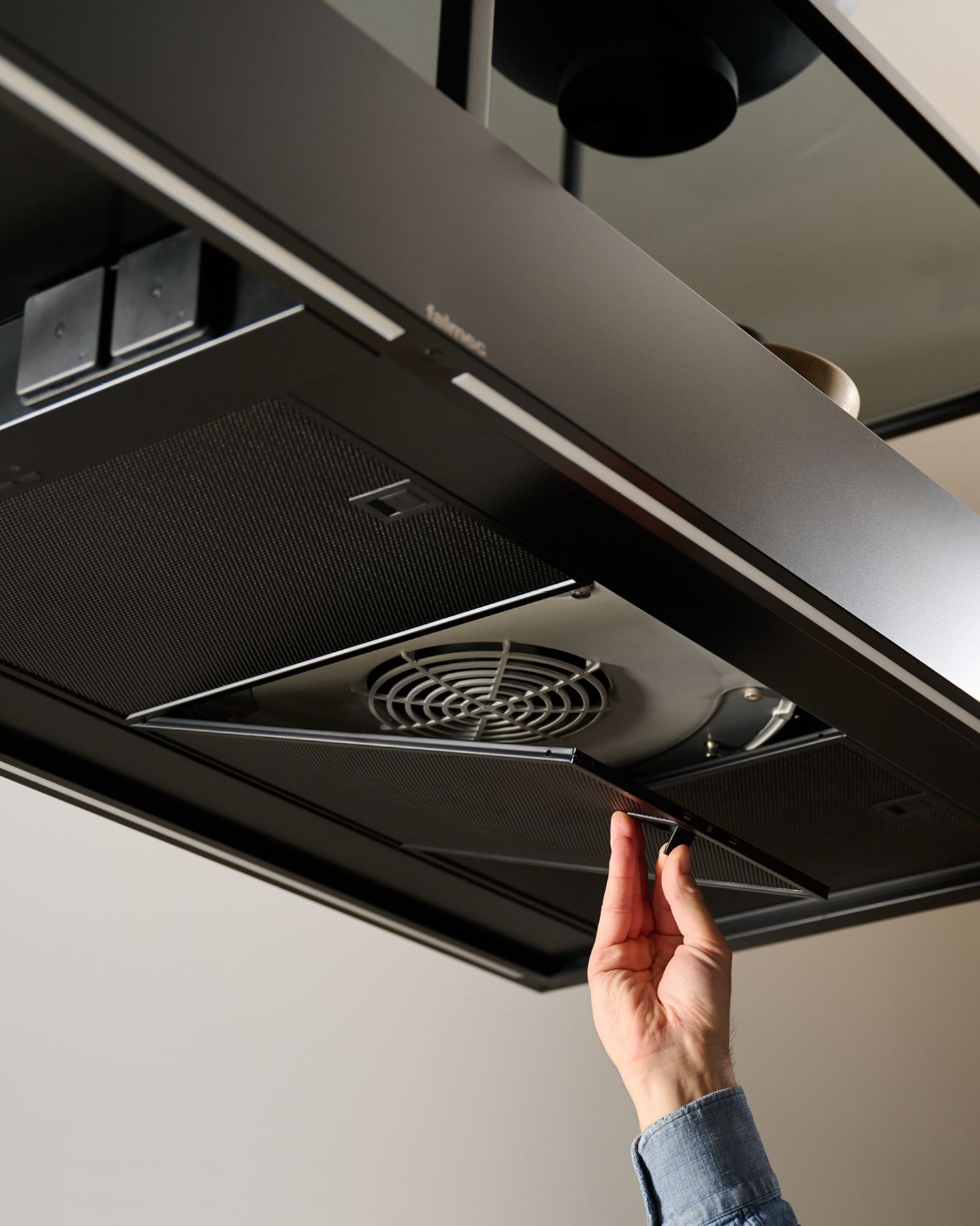 Uma pessoa está consertando um ventilador de teto em uma cozinha